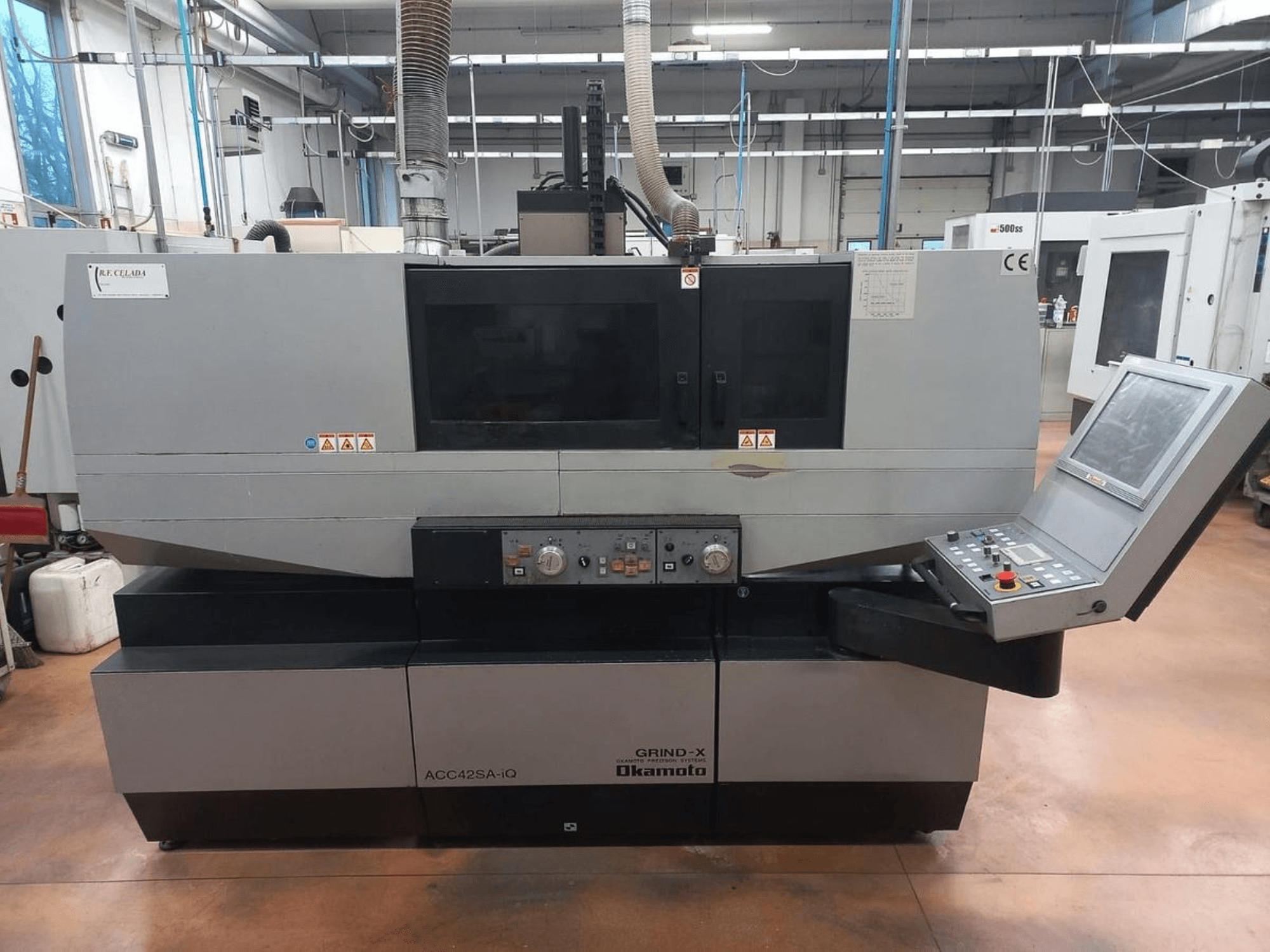 Vooraanzicht van de OKAMOTO ACC 42 SA-iQ vlakslijpmachine, met het bedieningspaneel en de veiligheidsindicatoren.