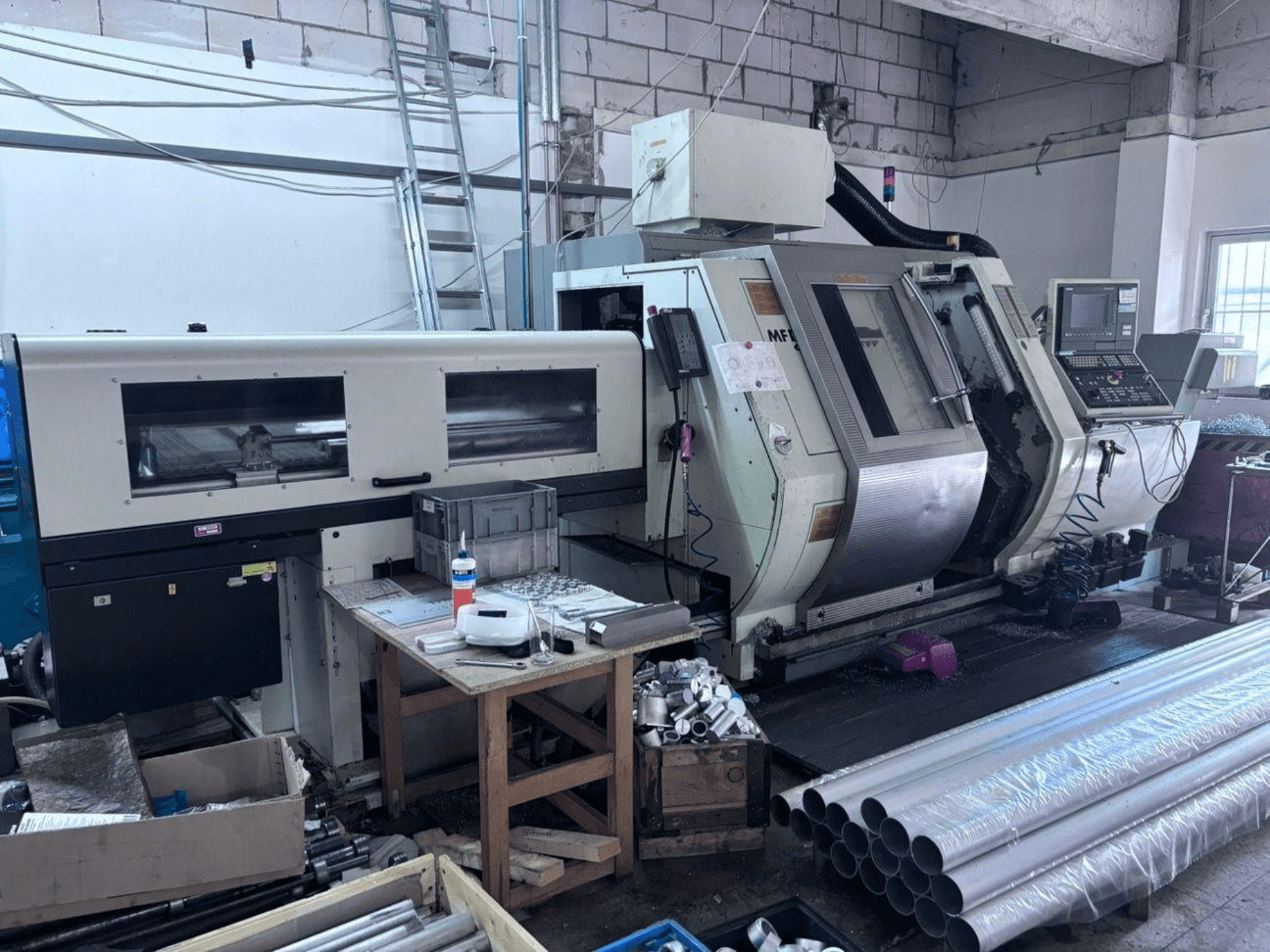 Gildemeister MF Twin 65 draai-freescentrum, zijaanzicht met bedieningspaneel, bewerkingsgebied en aluminium buizen.