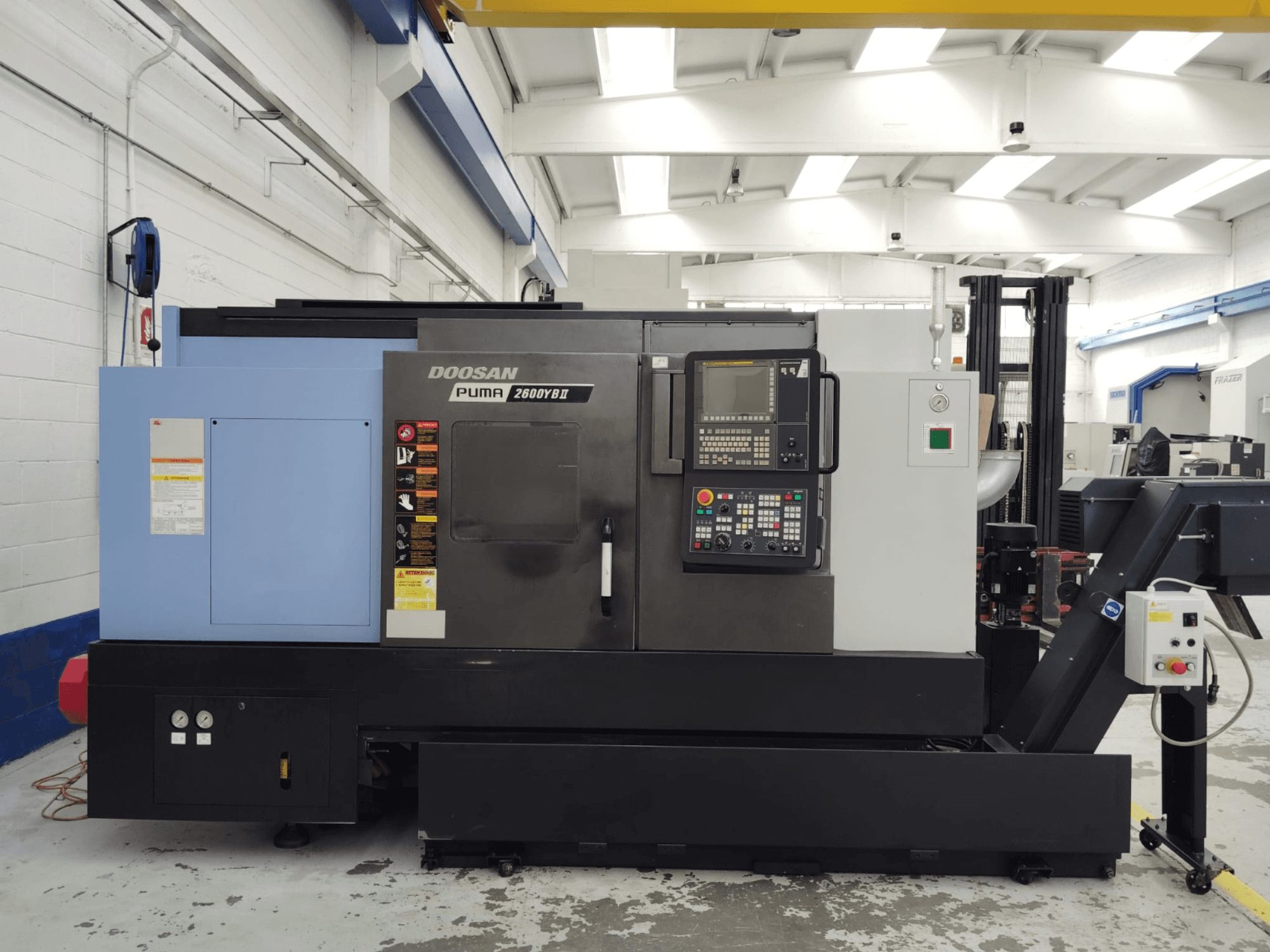 Vooraanzicht van de DOOSAN Puma 2600YB II horizontale draaimachine met het bedieningspaneel en de veiligheidslabels zichtbaar.