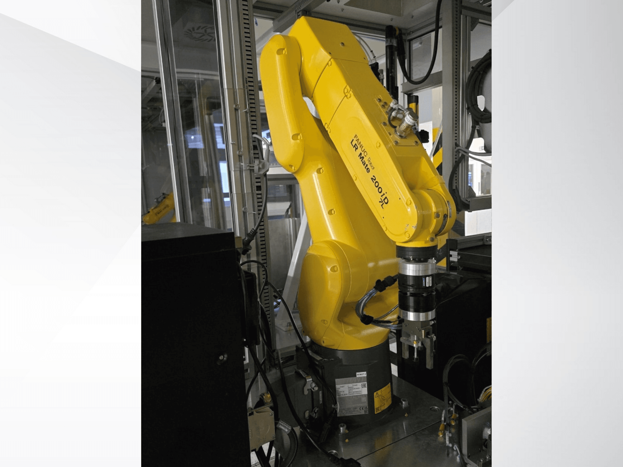 Gele Fanuc LR Mate 200iD robotarm in zijaanzicht, met grijper en verschillende kabels.