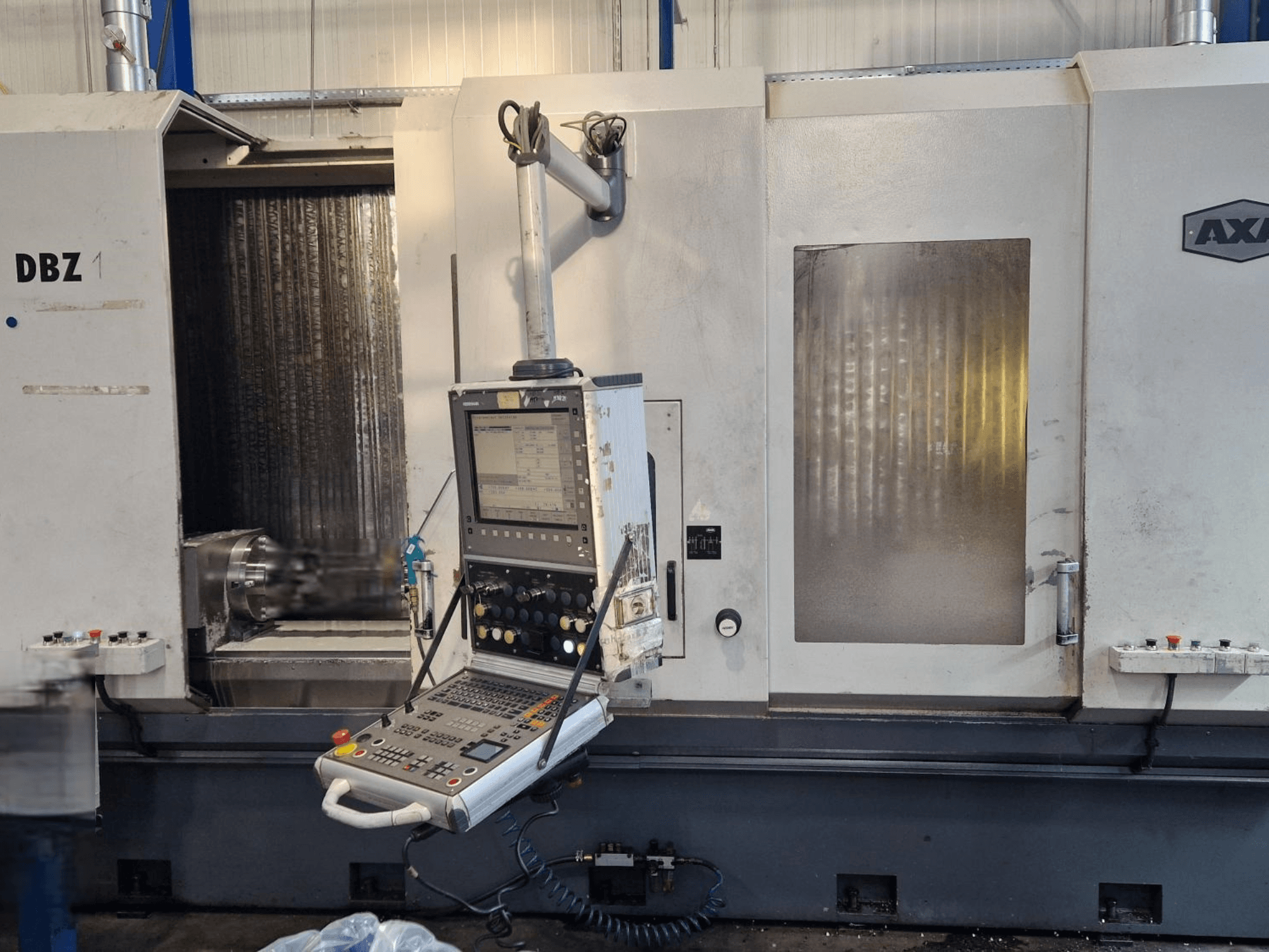 Verticaal AXA DBZ-bewerkingscentrum getoond vanuit een schuin vooraanzicht, met een bedieningspaneel en zichtbaar gebied voor snijgereedschap.