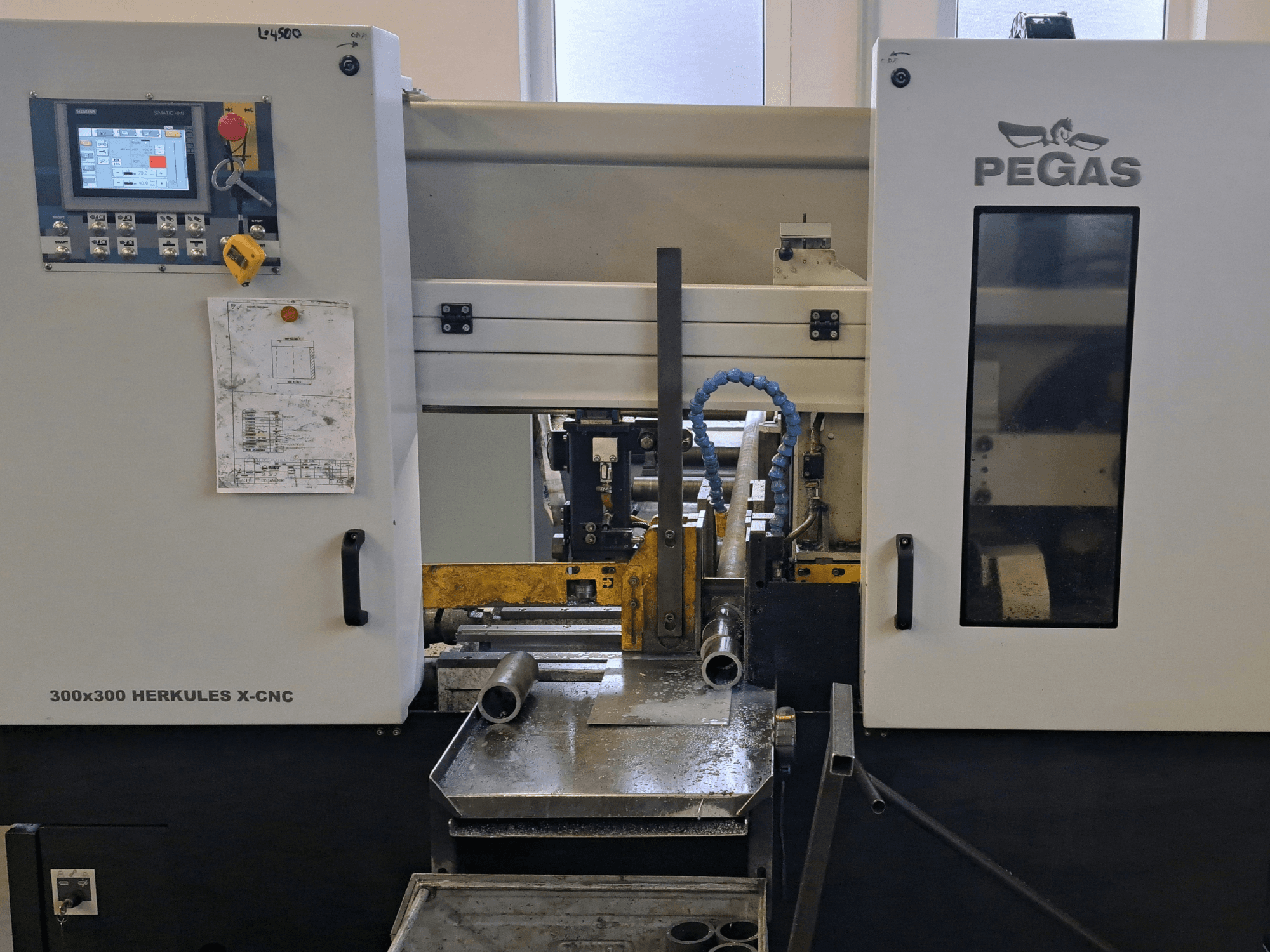 Pegas HERKULES X-CNC 300x300 plaatbewerkingsmachine, vooraanzicht, met het bedieningspaneel en het werkgebied met metalen onderdelen.