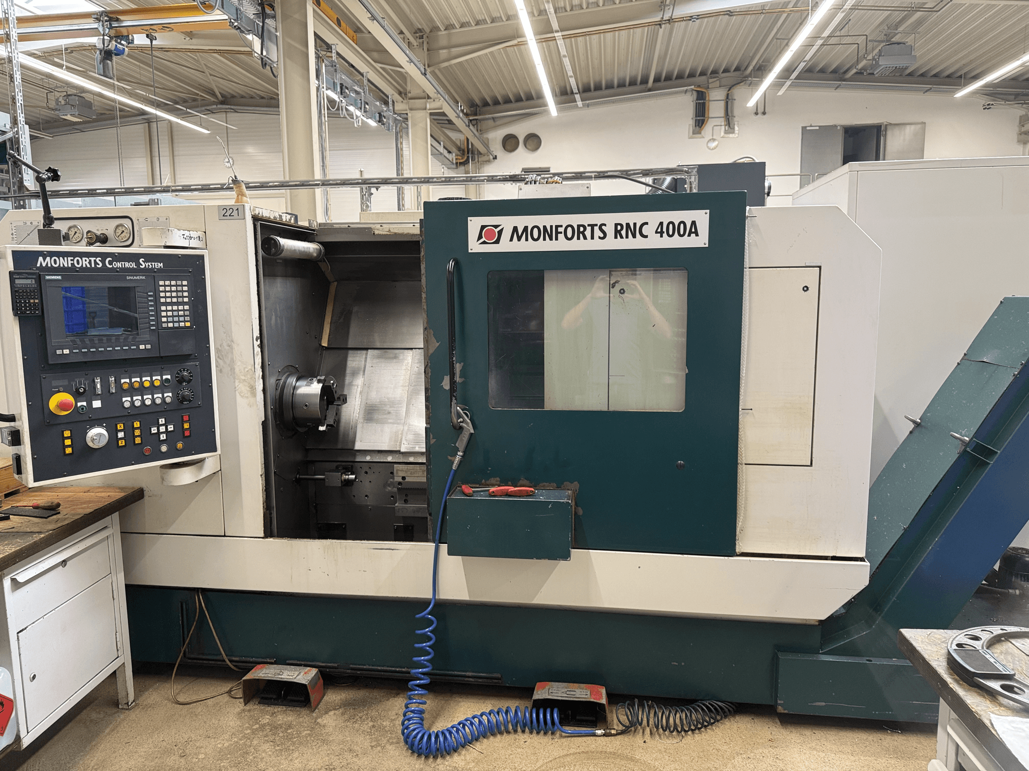 Monforts RNC 400 A horizontale draaibank, vooraanzicht, met het bedieningspaneel en het interieur van de machine.