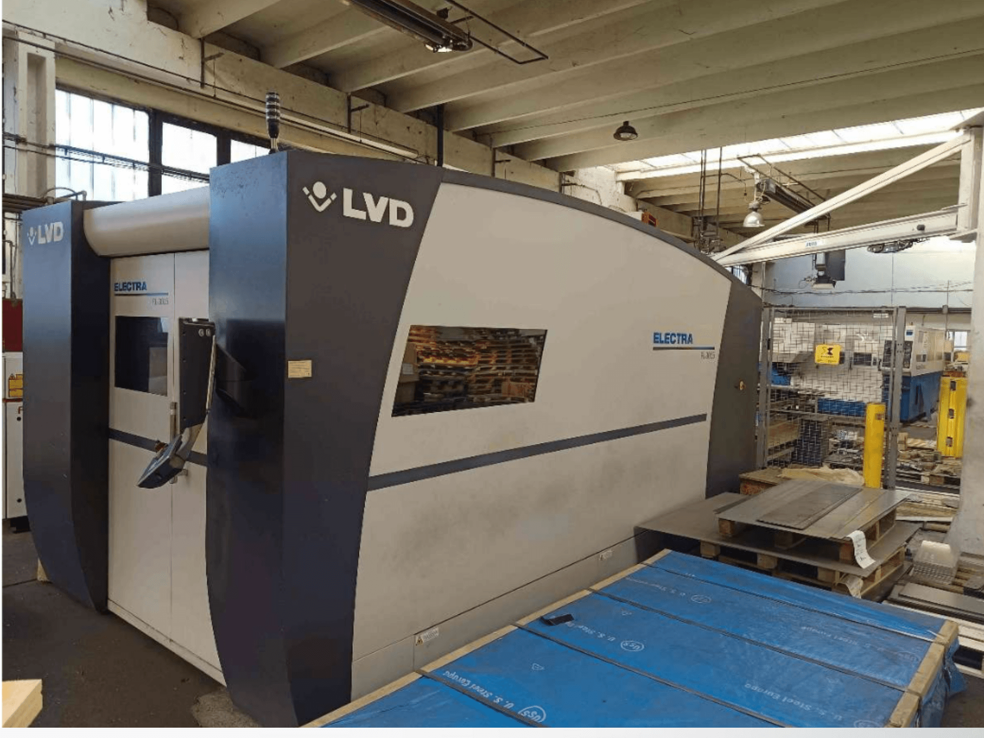 LVD Electra lasersnijmachine in zijaanzicht, met een strak design en een bedieningspaneel bij de deur, geplaatst in een werkplaats.