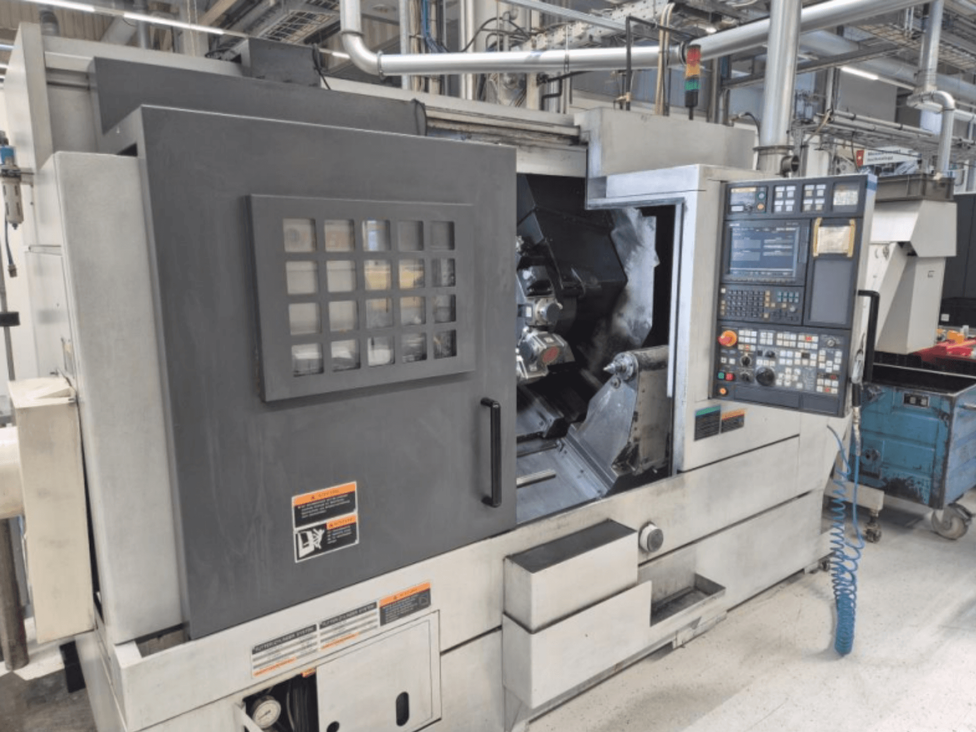 CNC draaibankmachine met bedieningspaneel, vooraanzicht. Met zichtbaar werkgebied en veiligheidsvenster, merk onbekend.