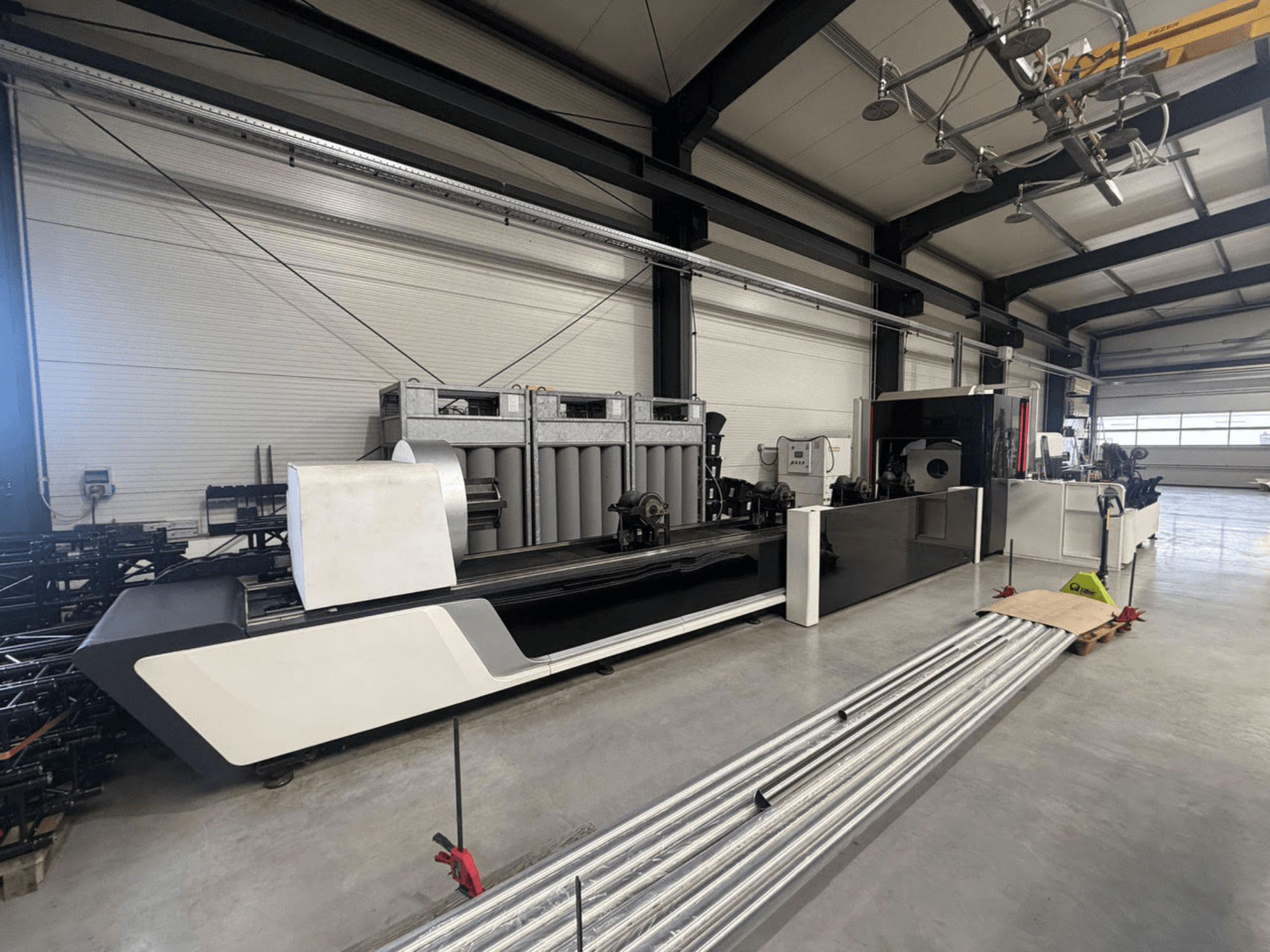 Bodor X2260 buizensnijmachine in een werkplaats, zijaanzicht met het machinehuis en metalen buizen op de vloer.
