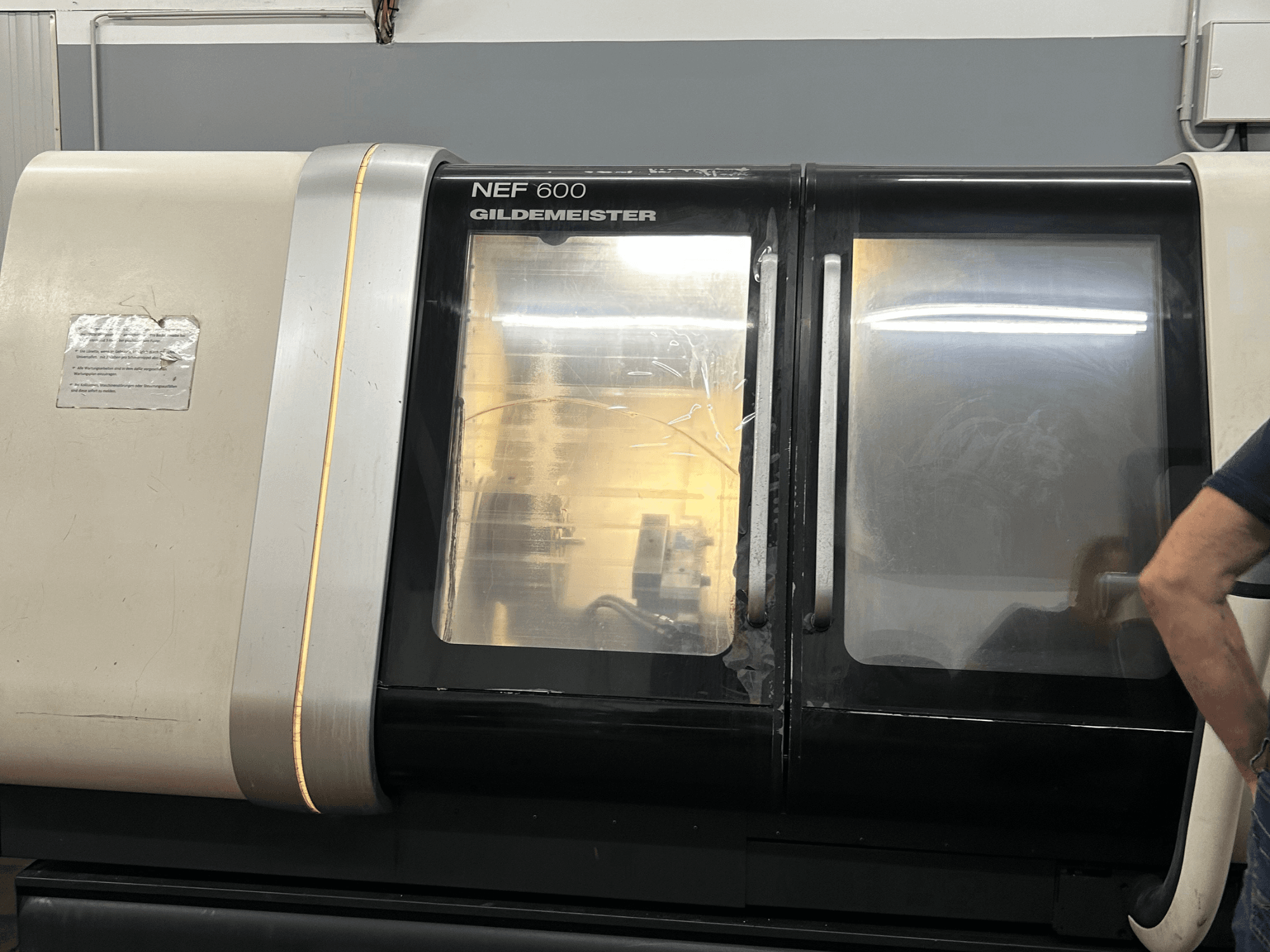 Horizontale draaimachine DMG NEF 600, vooraanzicht, met glanzende afwerking en grote kijkvensters.