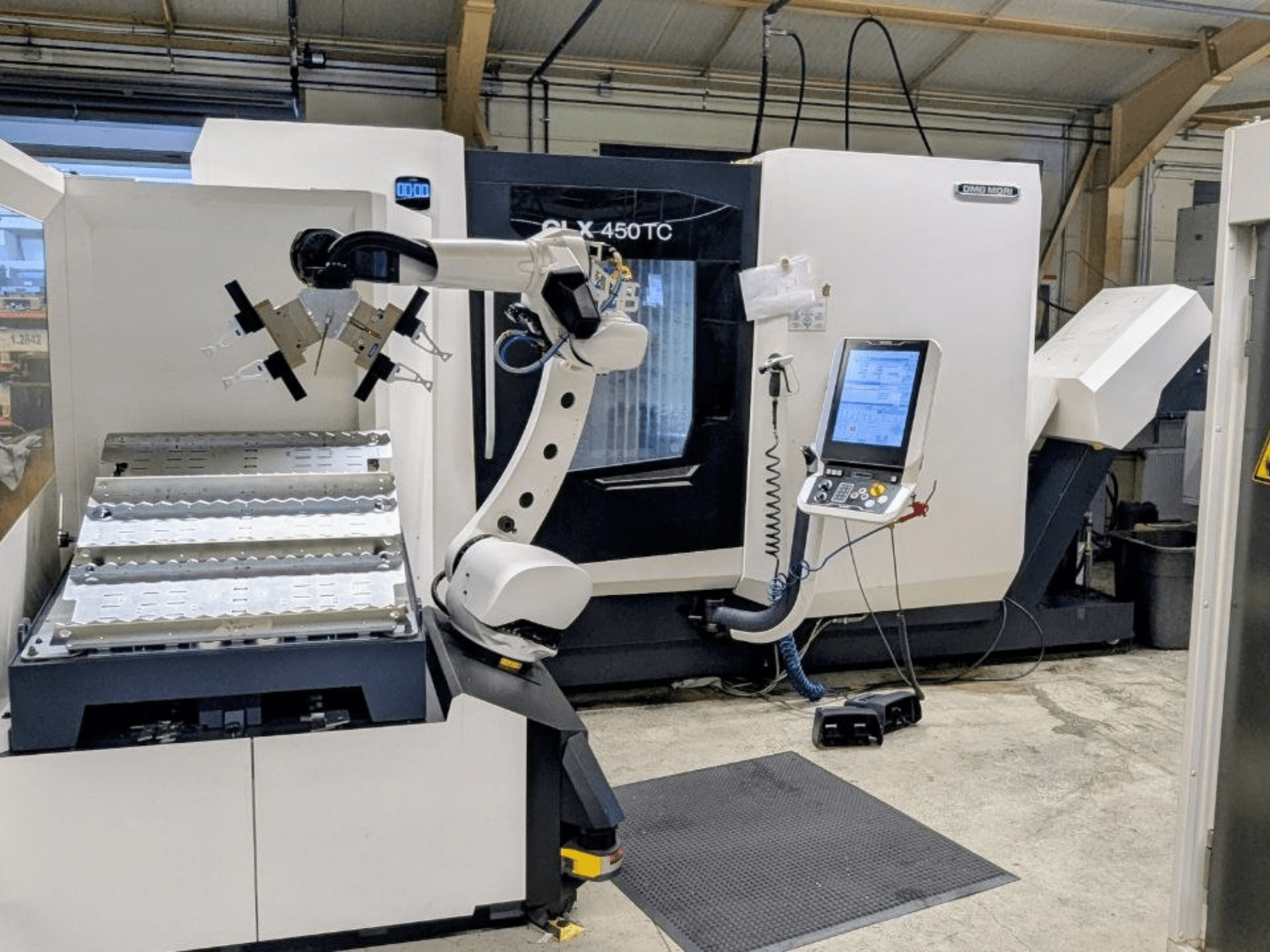 DMG MORI CLX 450 TC met Robo2go, vooraanzicht, met de robotarm en het bedieningspaneel naast de machine.