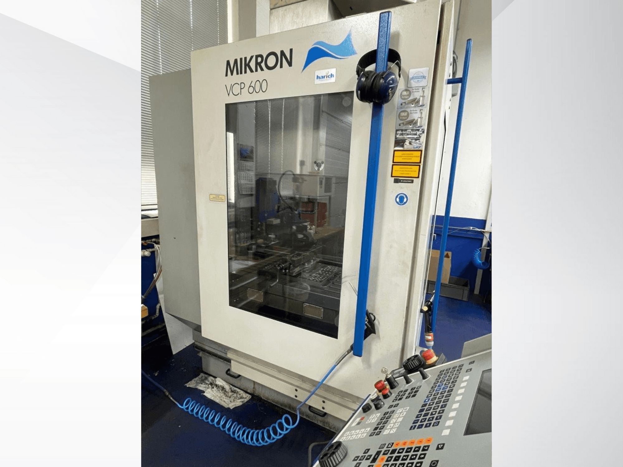 Mikron VCP 600 CNC machine, vooraanzicht, met bedieningspaneel met knoppen en zichtbaar bewerkingsgebied achter glas.