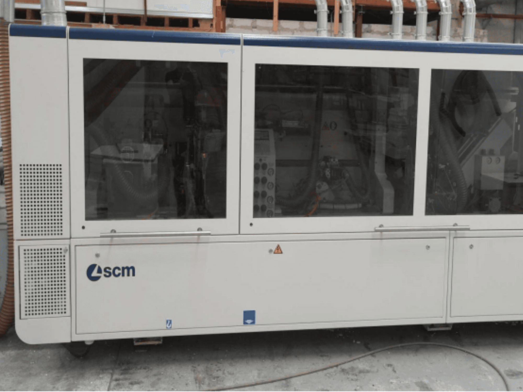 SCM industriële machine, zijaanzicht, heeft transparante panelen en zichtbare ventilatieopeningen; ontworpen voor efficiëntie in productieprocessen.