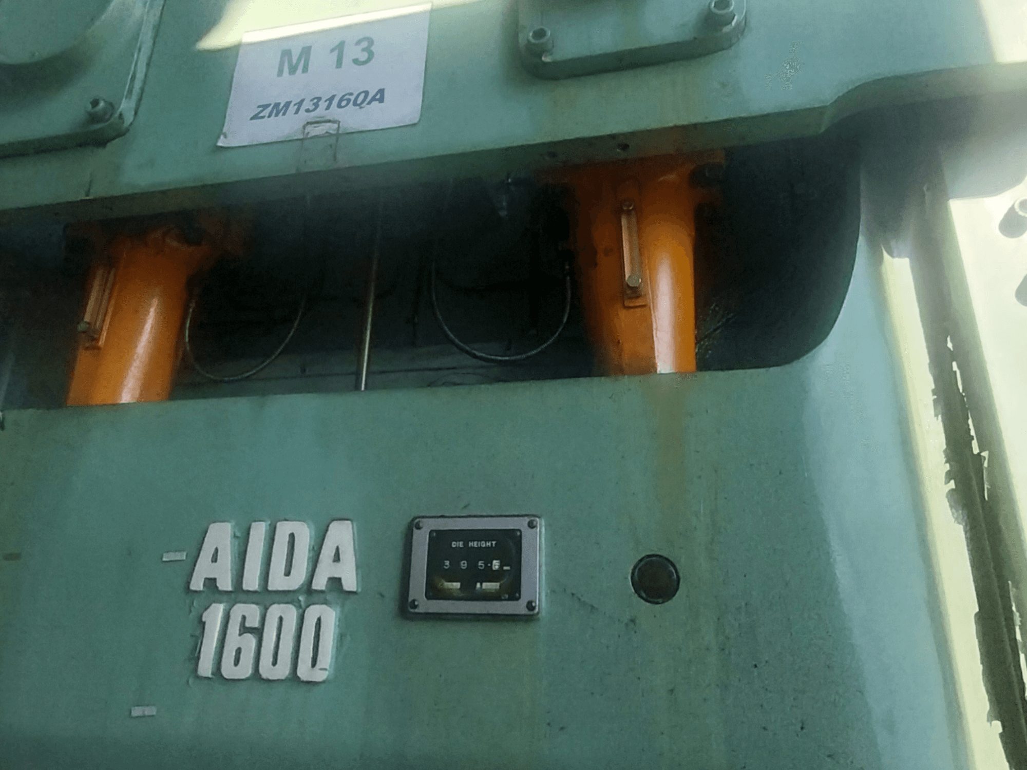 AIDA NC2-1600 mechanische stempelpers, vooraanzicht; oranje hydraulische onderdelen en matrijshoogtemeter zichtbaar.