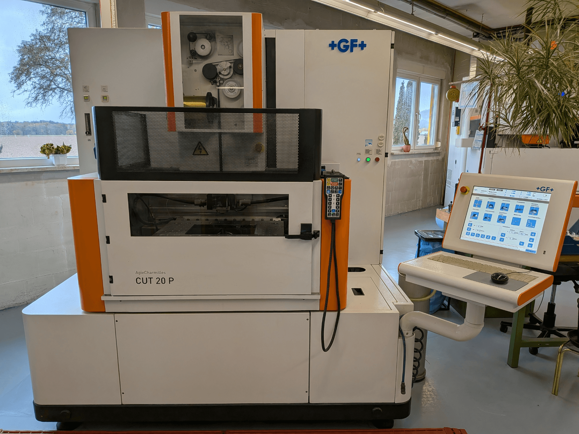 Een AgieCharmilles Cut-20 P draadvonkmachine, gezien van voren met bedieningspaneel en display, opgesteld in een goed verlichte werkplaats.