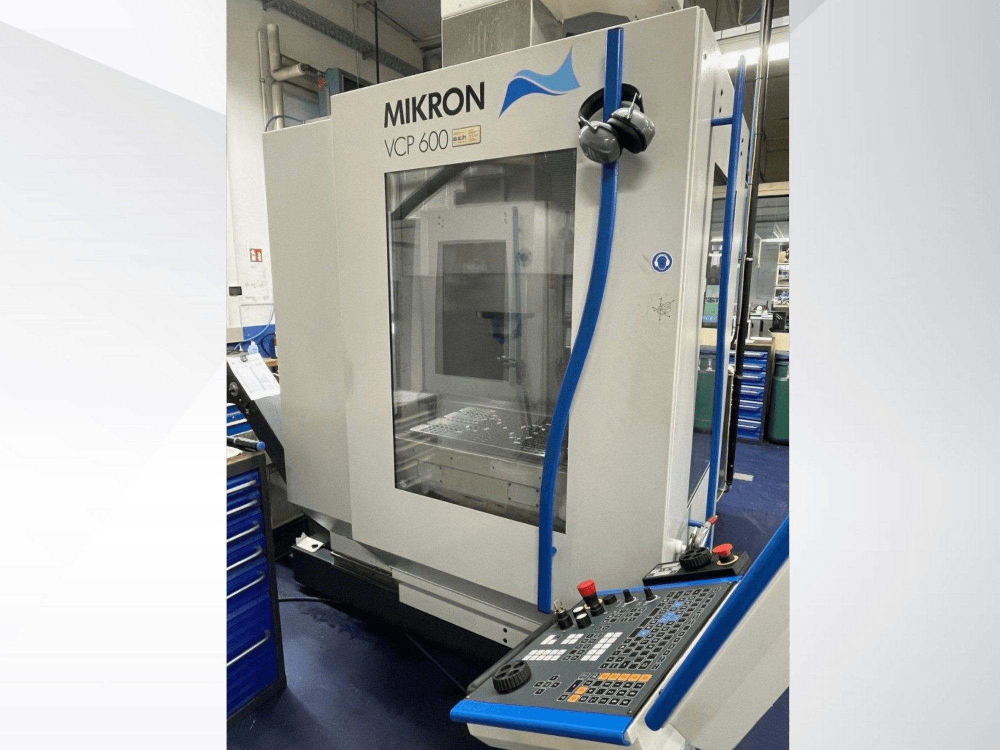 Mikron VCP 600 bewerkingscentrum in een werkplaats, vooraanzicht, met een bedieningspaneel met knoppen en draaiknoppen.