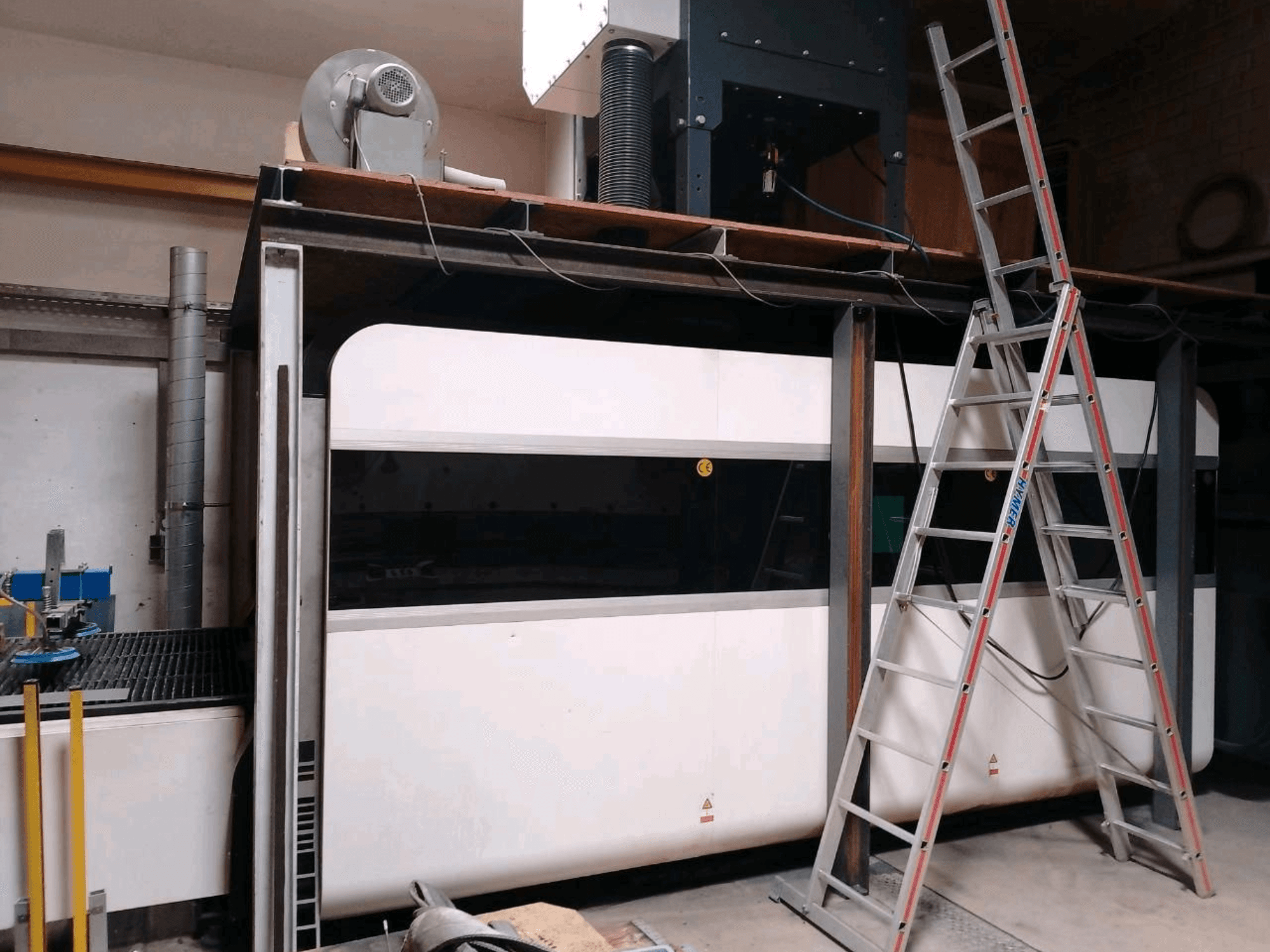 GWEIKE LF3015GA-vezellasersnijmachine in een werkplaats, met een vooraanzicht, het metalen frame en de toegangsladder.