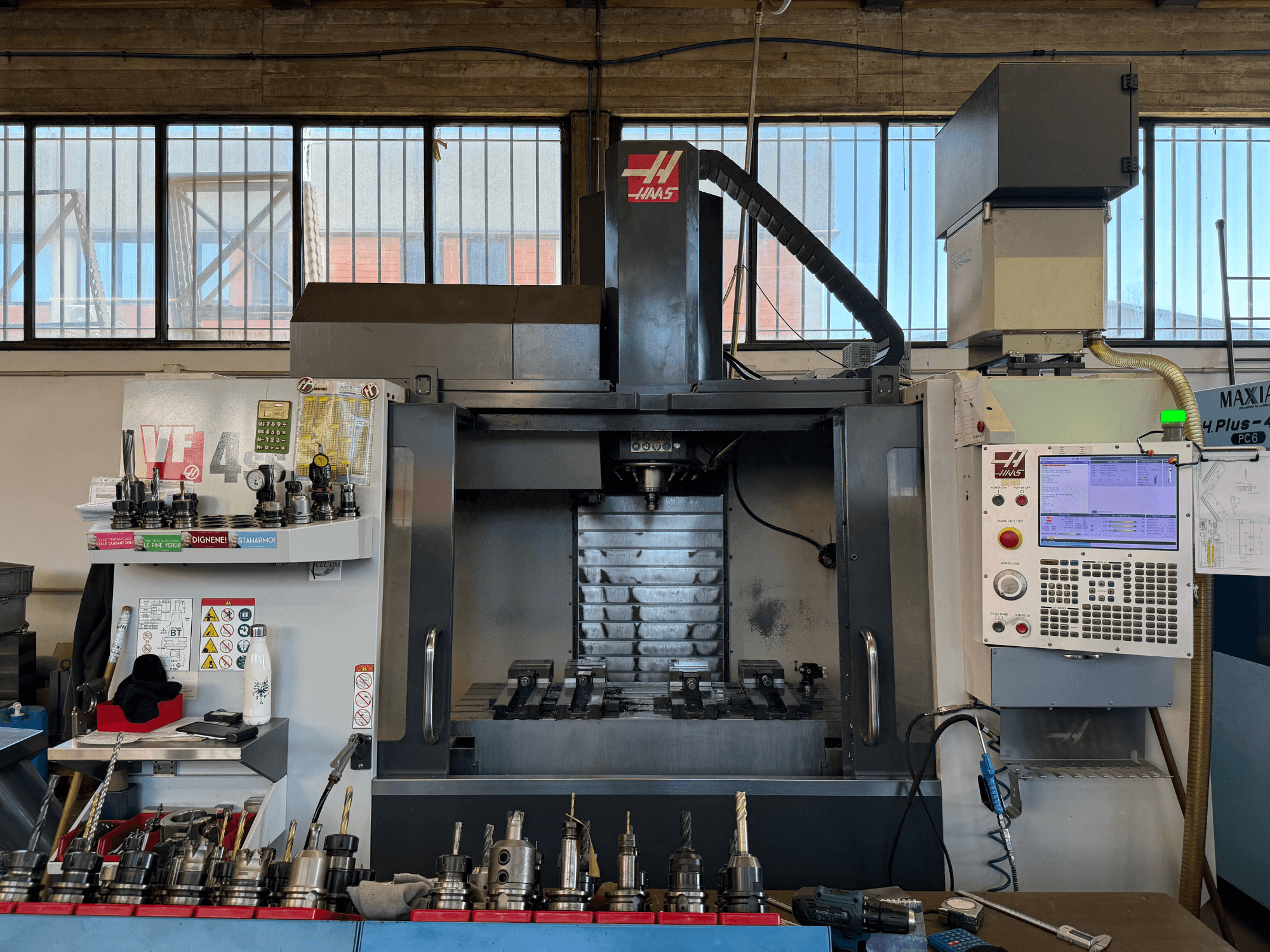 HAAS VF-4SS verticaal bewerkingscentrum, vooraanzicht, met bedieningspaneel, gereedschapshouders en zichtbaar spindelgedeelte.