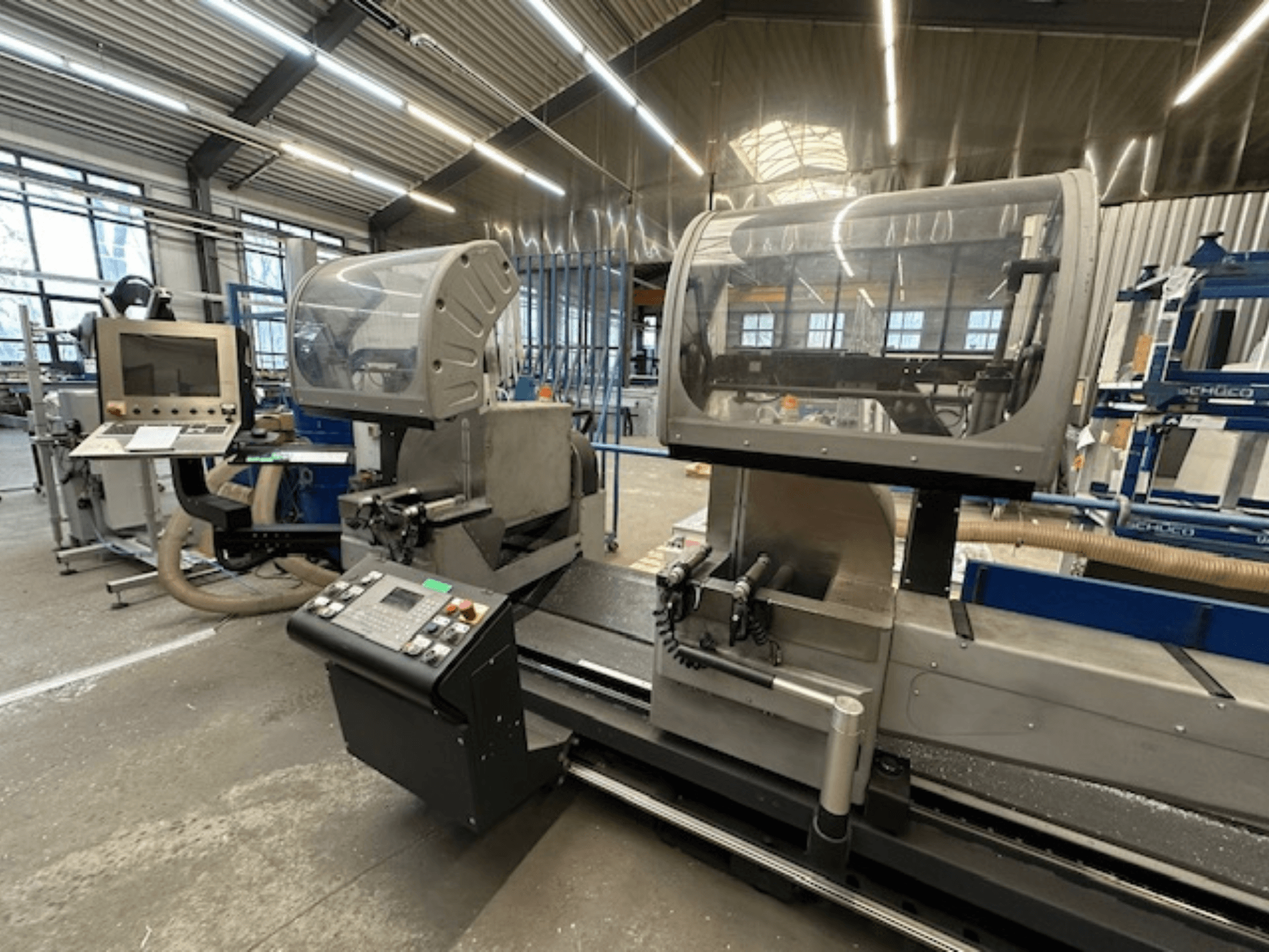 SCHÜCO PDG E CUT metaalcirkelzaag, vooraanzicht, met bedieningspaneel, beschermkappen en zaagzone in een werkplaats.