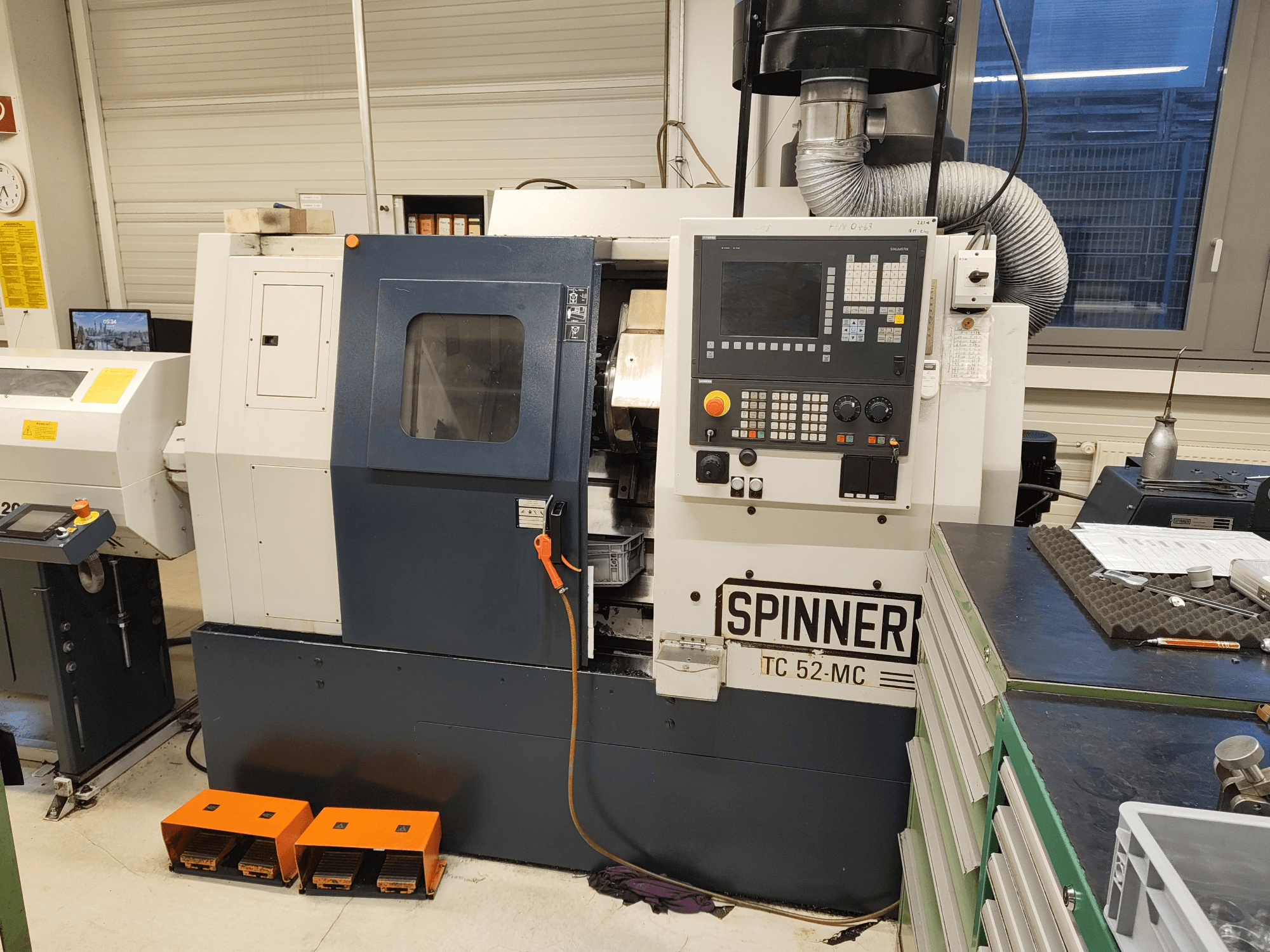 Horizontale draaimachine SPINNER TC 52 MC in een werkplaats, vooraanzicht, met het bedieningspaneel, het bewerkingsgebied en de veiligheidsvoorzieningen.