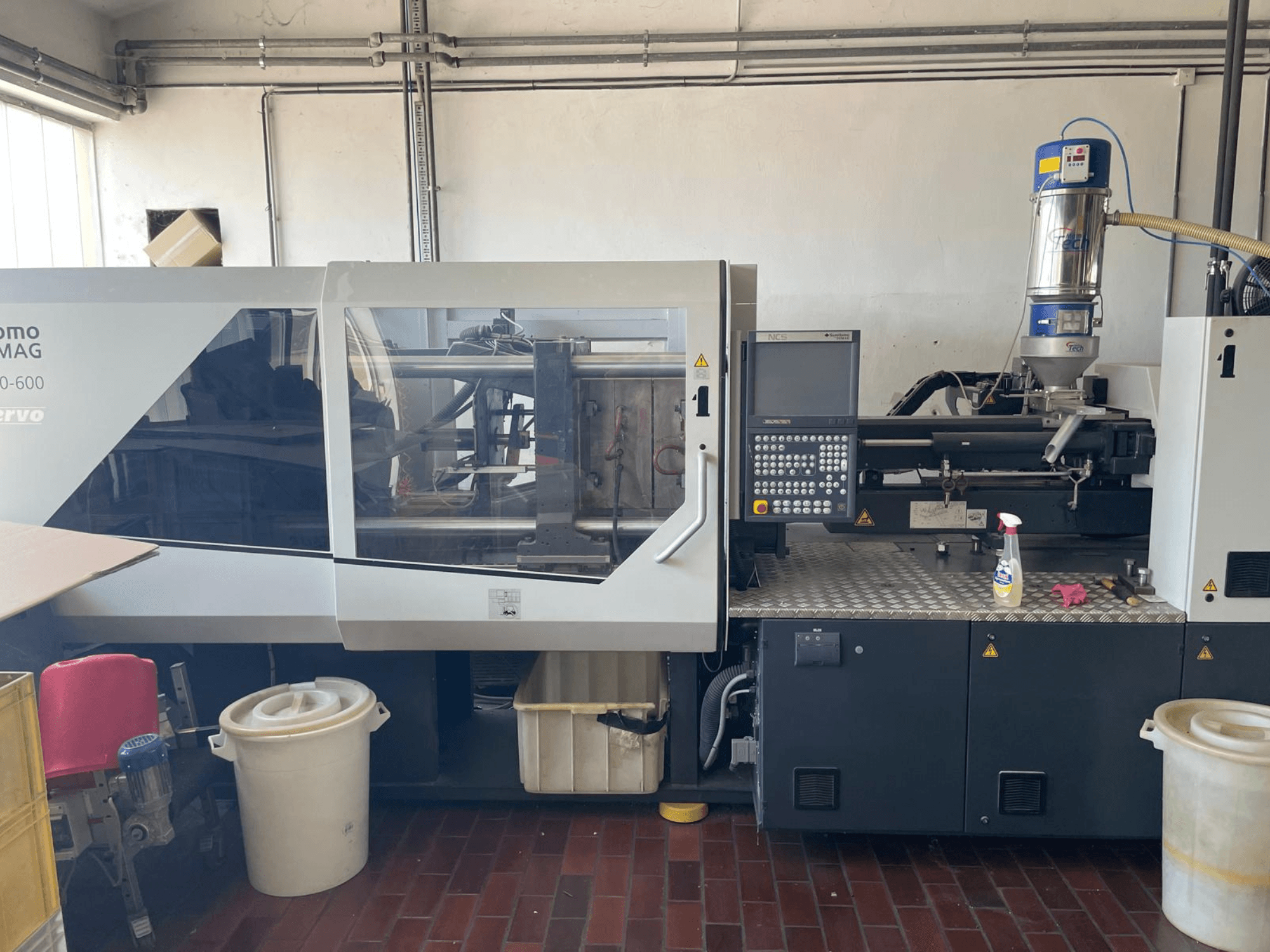Vooraanzicht van SUMITOMO SHI DEMAG Systec 160/520-600 hydraulische spuitgietmachine met bedieningspaneel en aanvoereenheid.