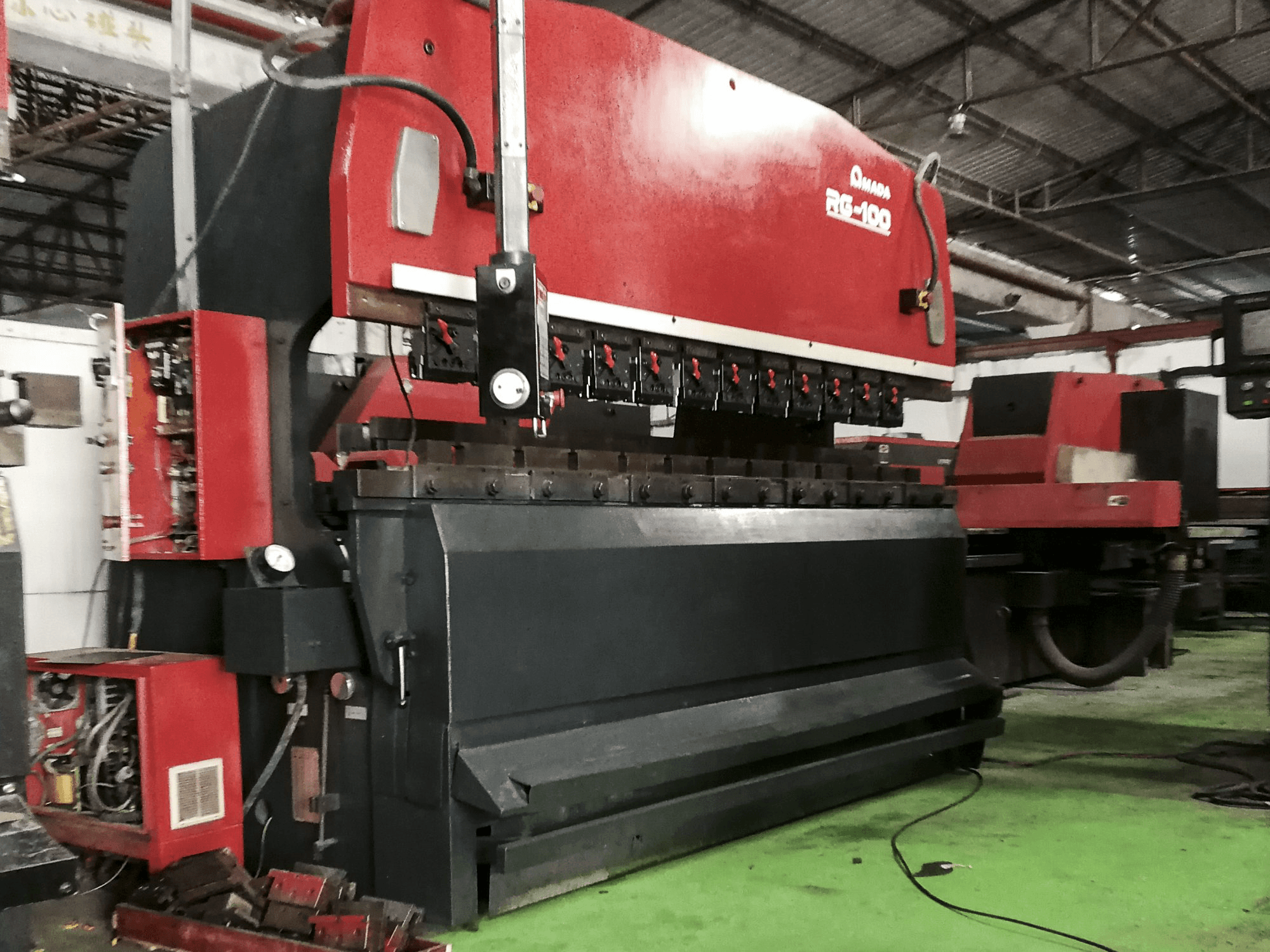 Links zicht van AMADA RG-100 machine