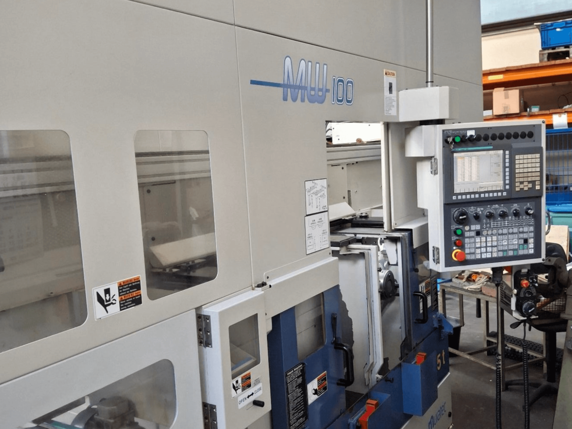Muratec MW 100 GT meerspillige draaimachine, vooraanzicht, met het bedieningspaneel en de machinecompartimenten.