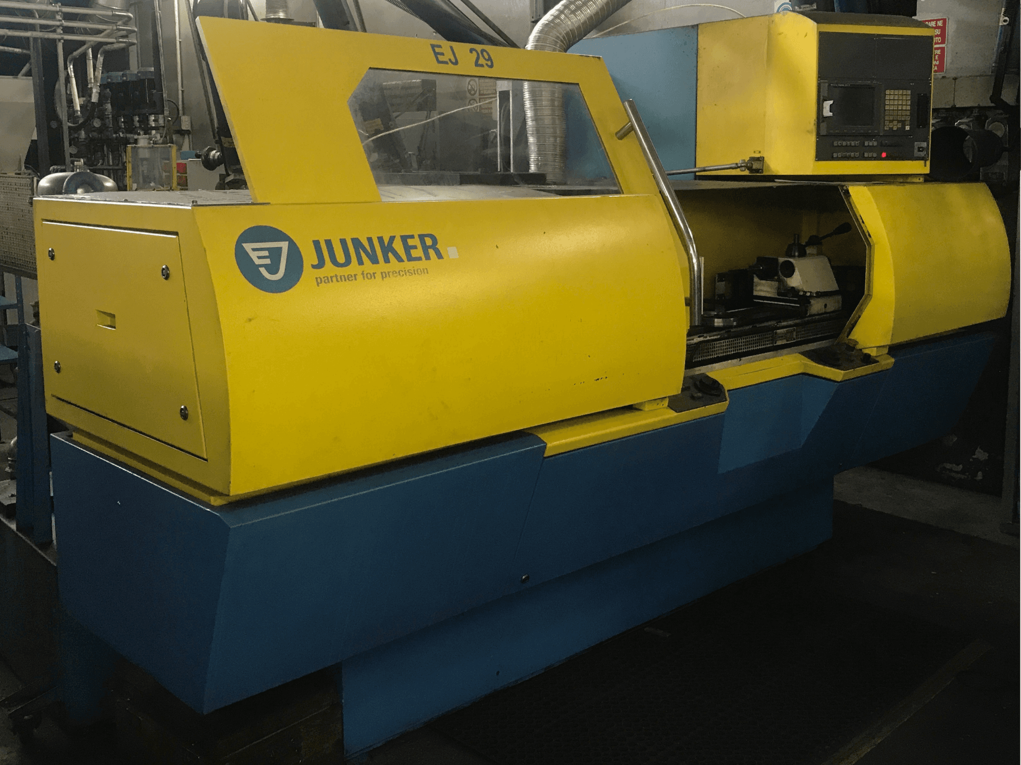 JUNKER EJ 29 slijpmachine, vooraanzicht, met geel en blauwe behuizing, bedieningspaneel en zichtbare interne onderdelen.