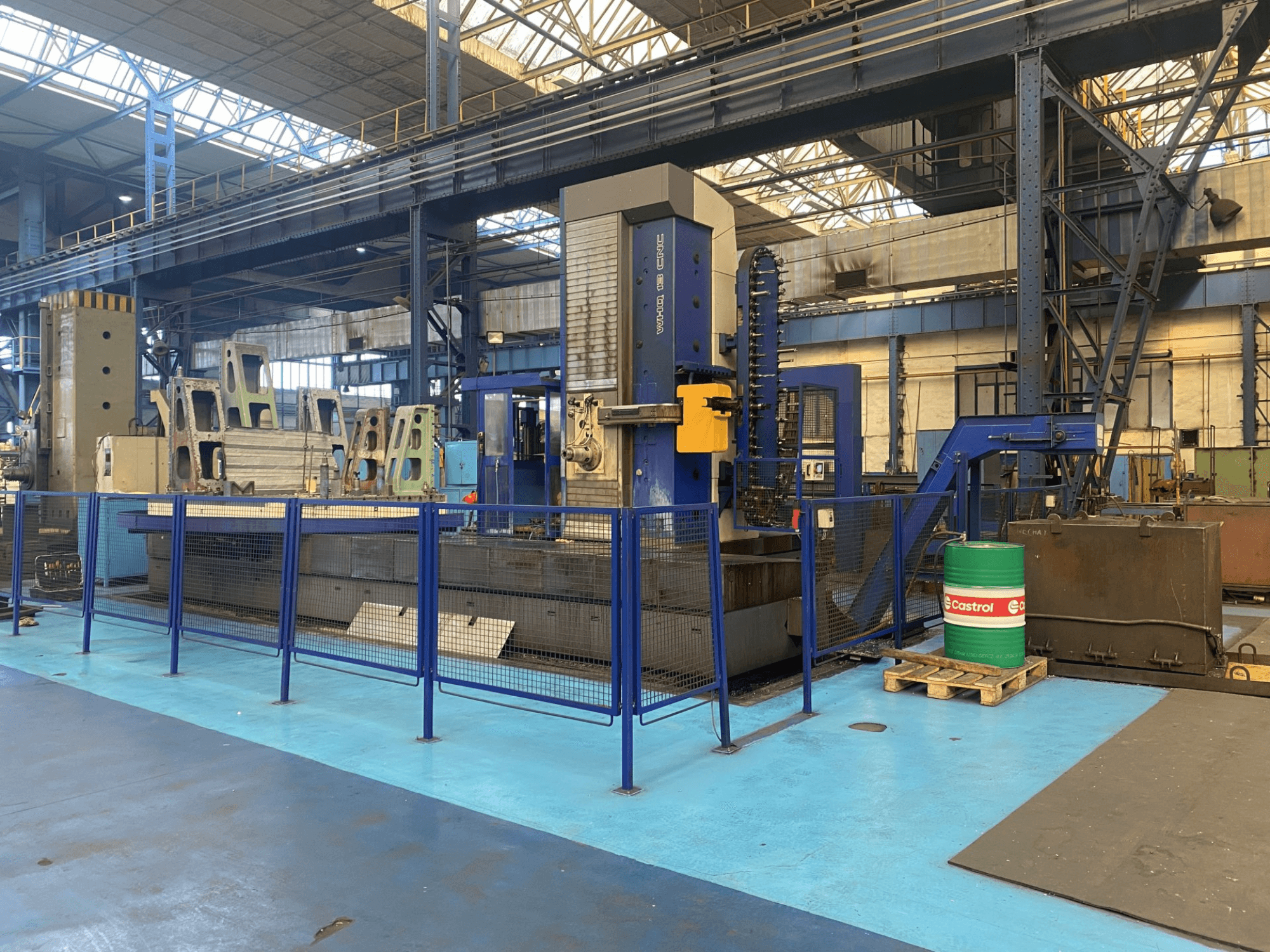 TOS WHQ 13 CNC kottermachine in een werkplaats, vooraanzicht, met blauw frame en omringend veiligheidshek.