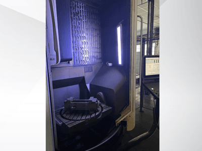 DMG MORI DMU 65 MonoBlock verticaal bewerkingscentrum, vooraanzicht met draaitafel met werkstuk en bedieningspaneel.