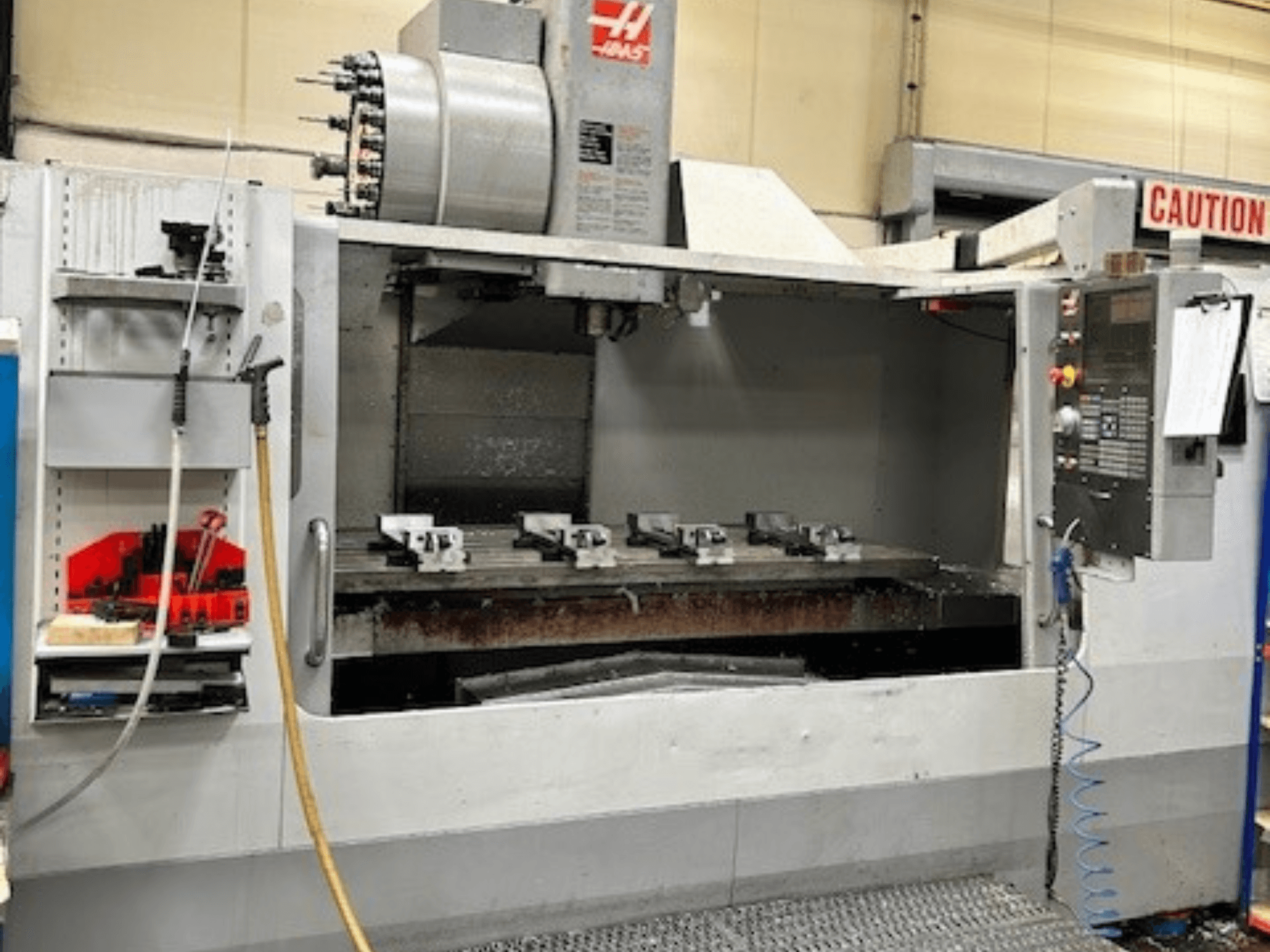 HAAS VF-9/40HE verticaal bewerkingscentrum, vooraanzicht, met gereedschaphouder en accessoires zichtbaar aan de zijkant.