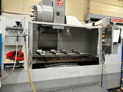HAAS VF-9/40HE verticaal bewerkingscentrum, vooraanzicht, met gereedschaphouder en accessoires zichtbaar aan de zijkant.