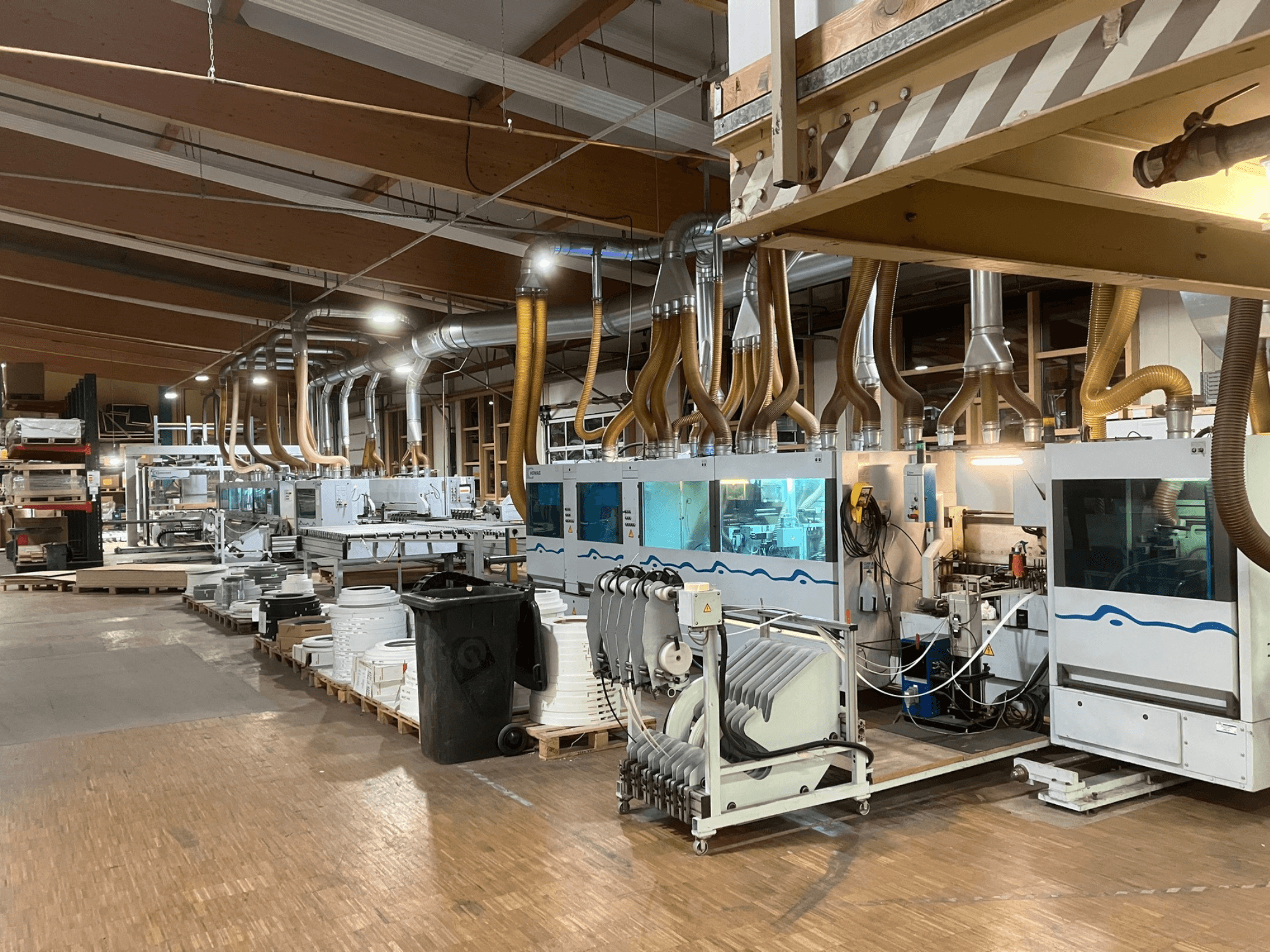HOMAG KBZ KFR20 dubbelzijdige kantenlijmmachine, gezien vanaf de zijkant, uitgerust met afzuigkanalen en toebehoren in een werkplaatsomgeving.