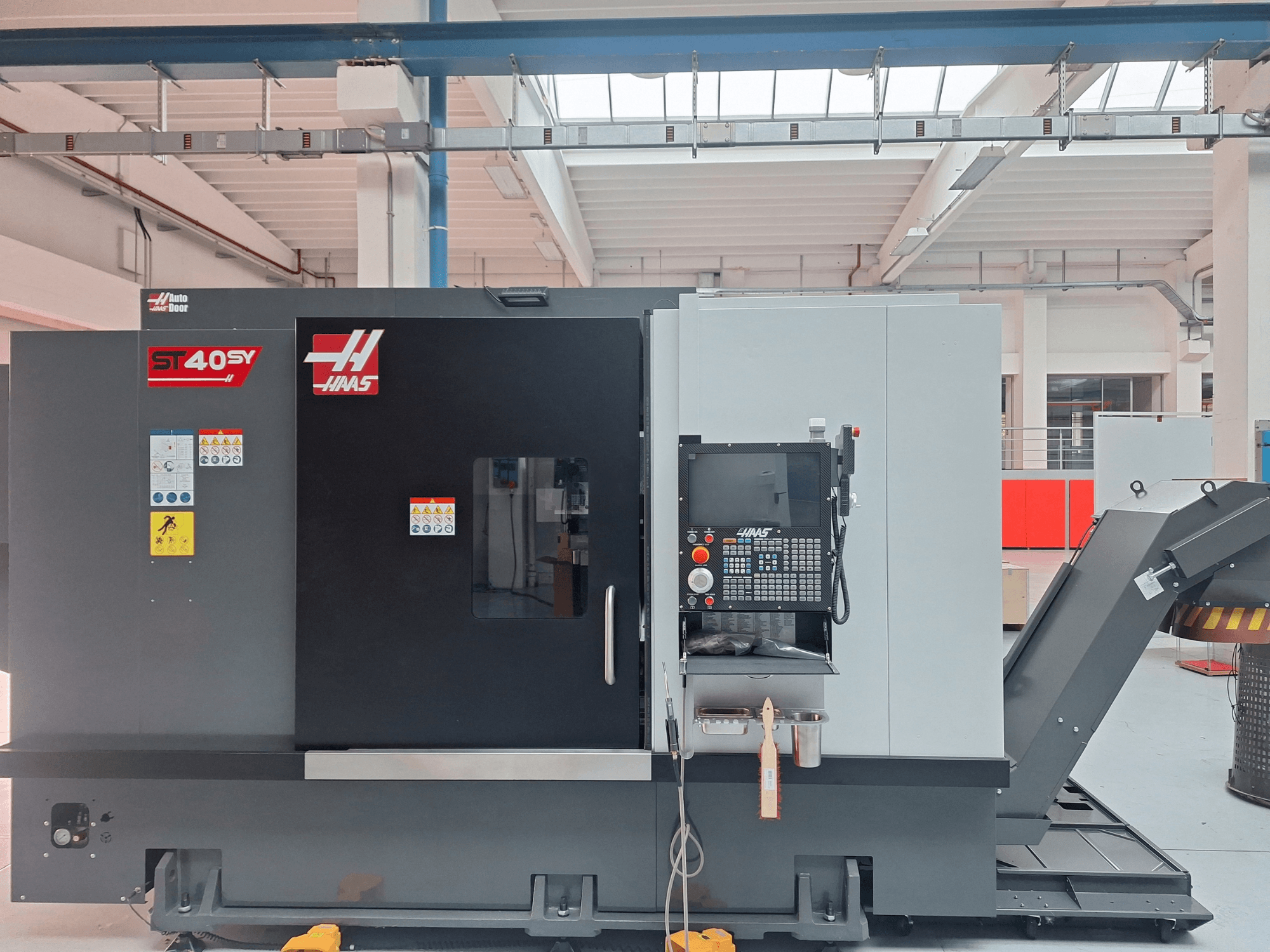 Haas ST-40SY horizontale draaimachine in zijaanzicht, met bedieningspaneel en veiligheidsstickers.