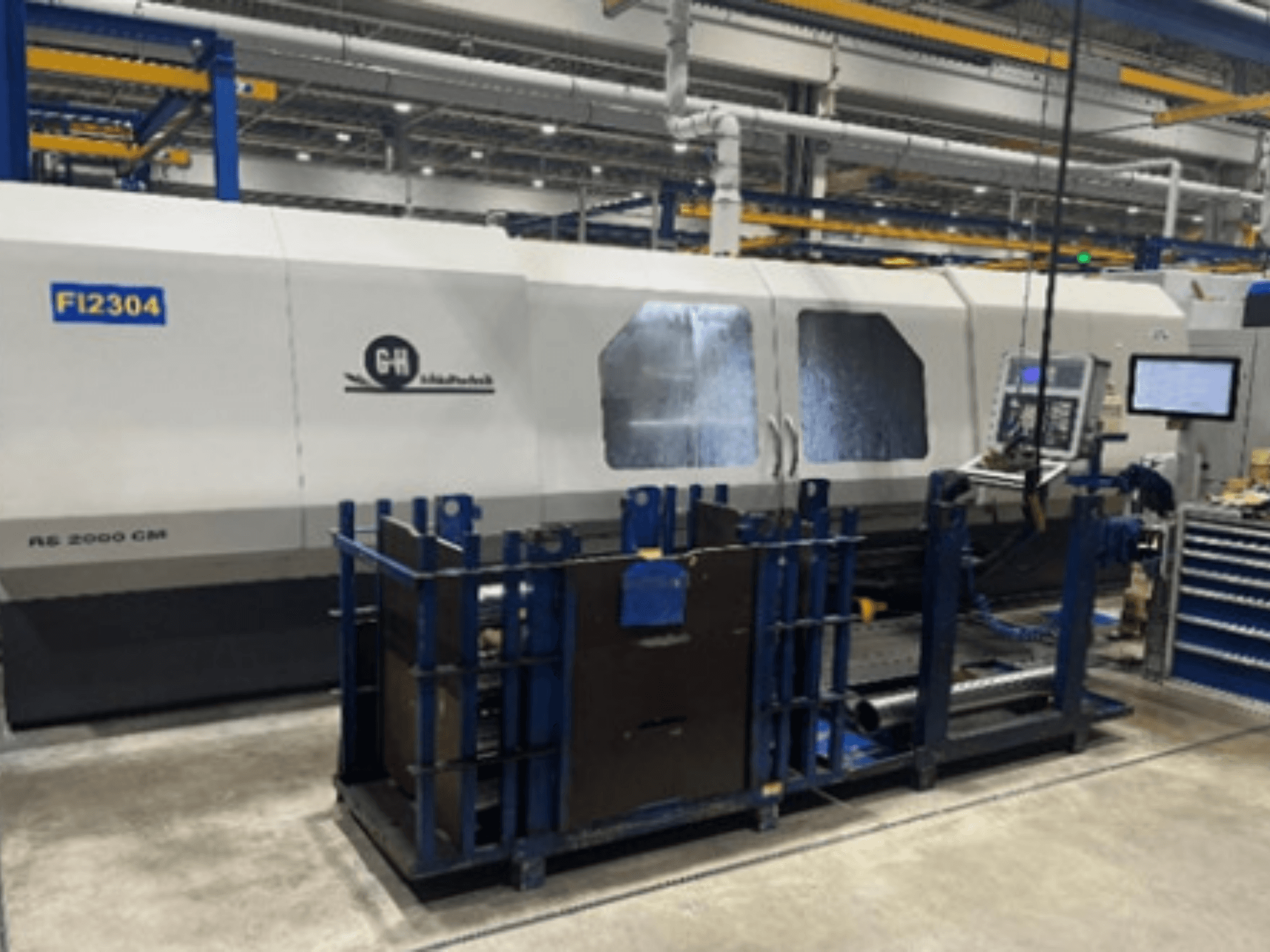 GH RS 2000 CM CNC machine in een fabrieksopstelling, gezien vanaf de zijkant, met bedieningspaneel en werkstukhouder.