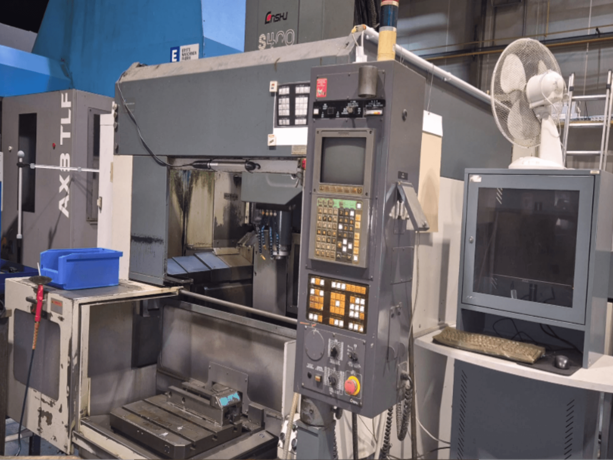 Verticaal bewerkingscentrum Enshu S400 in een werkplaats, met het bedieningspaneel, de monitor en het werkgebied van de machine.