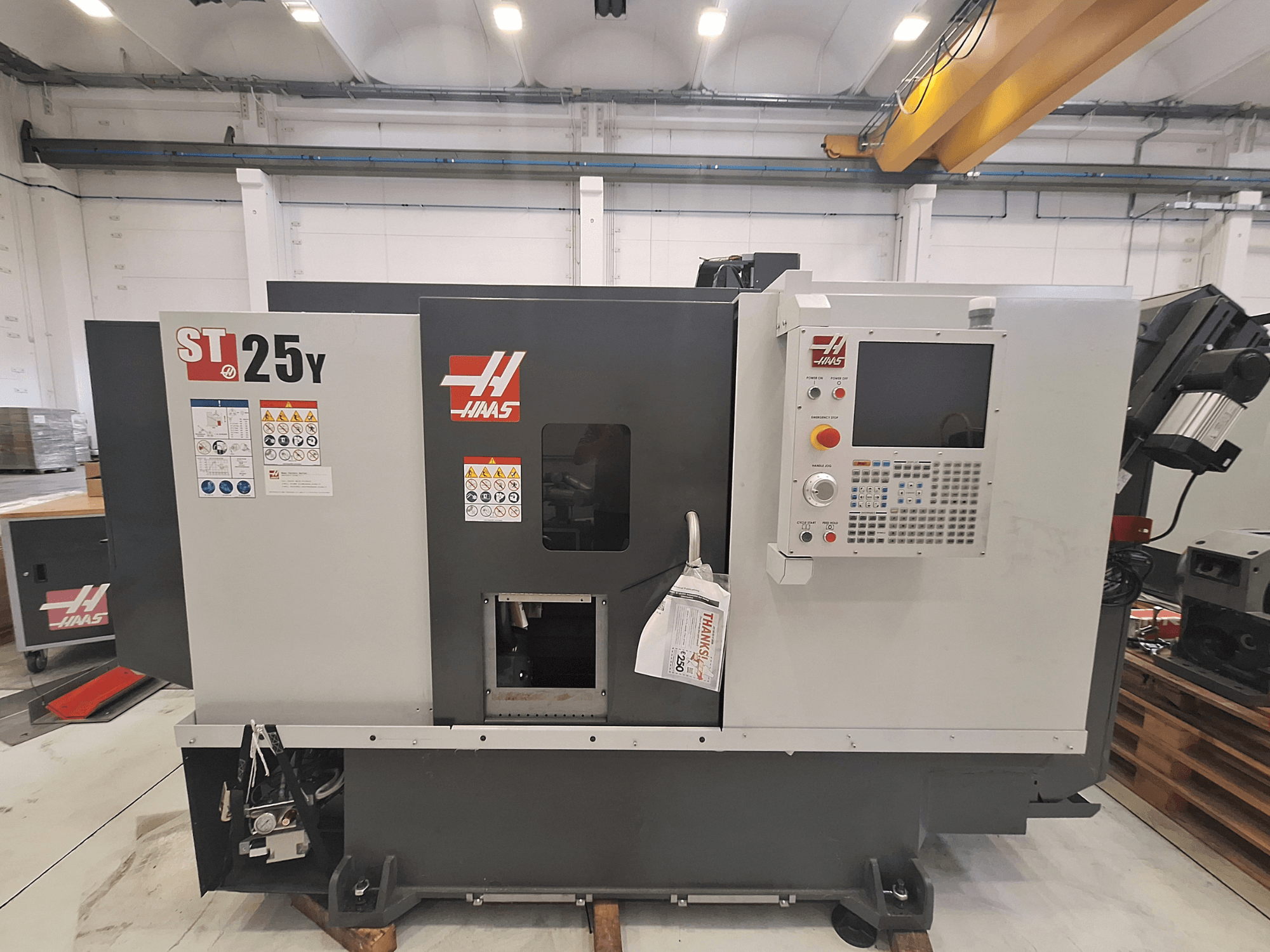 Haas ST-25Y horizontale draaimachine, vooraanzicht, met bedieningspaneel en veiligheidsstickers. Ideaal voor precisiebewerking.
