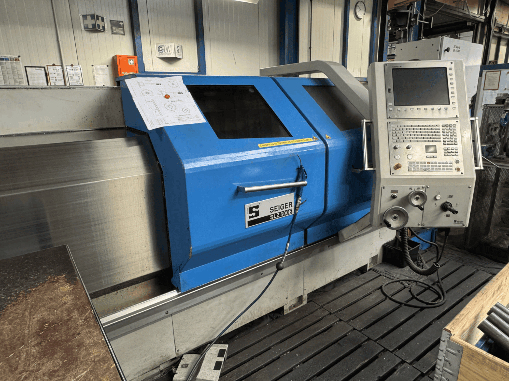 Vooraanzicht van de SEIGER SLZ 500E horizontale draaimachine met bedieningspaneel, blauwe behuizing en een getoonde technische tekening.
