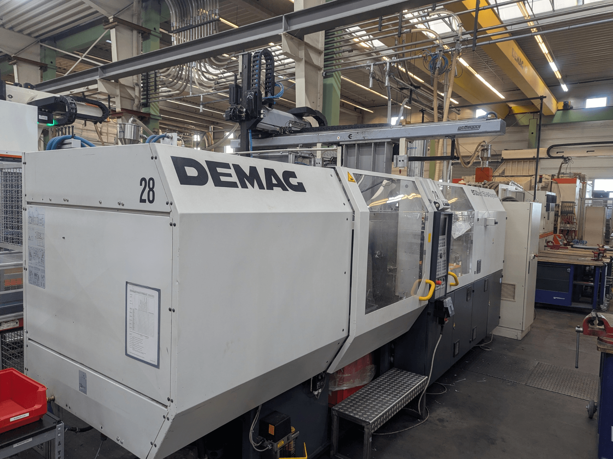 Vooraanzicht van een DEMAG ERGOTECH 1500-840 hydraulische spuitgietmachine, met de bedieningselementen en veiligheidsfuncties.