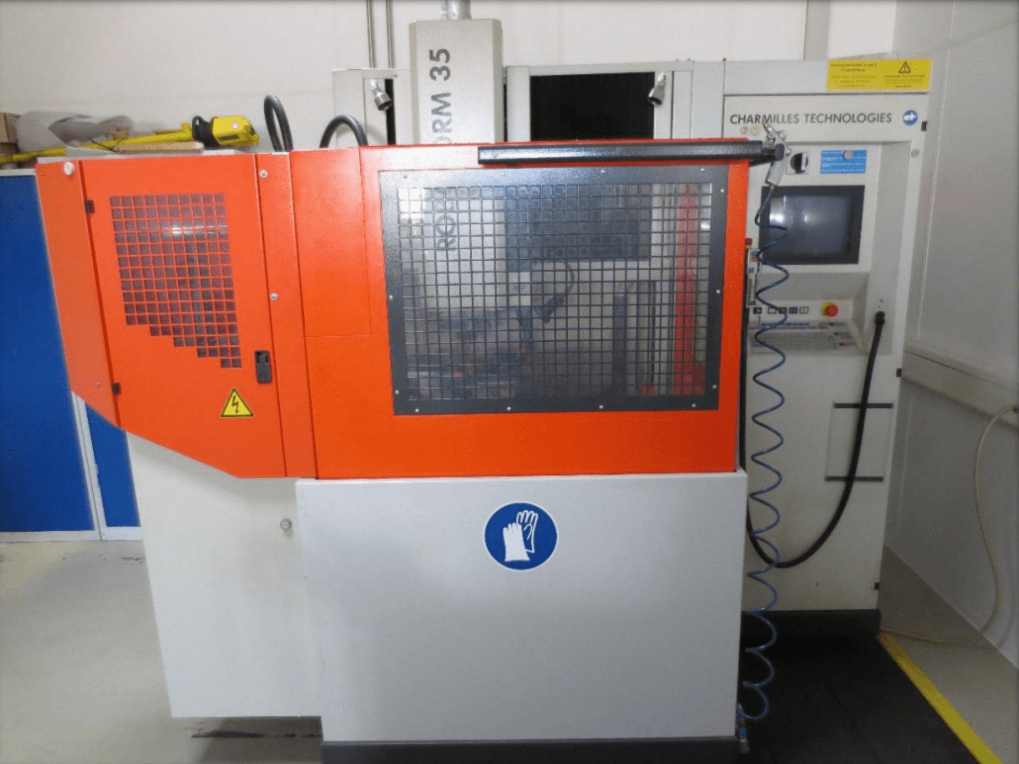 Vooraanzicht van de CHARMILLES Roboform 35 zink-EDM-machine, met rode panelen en de bedieningsinterface in beeld.