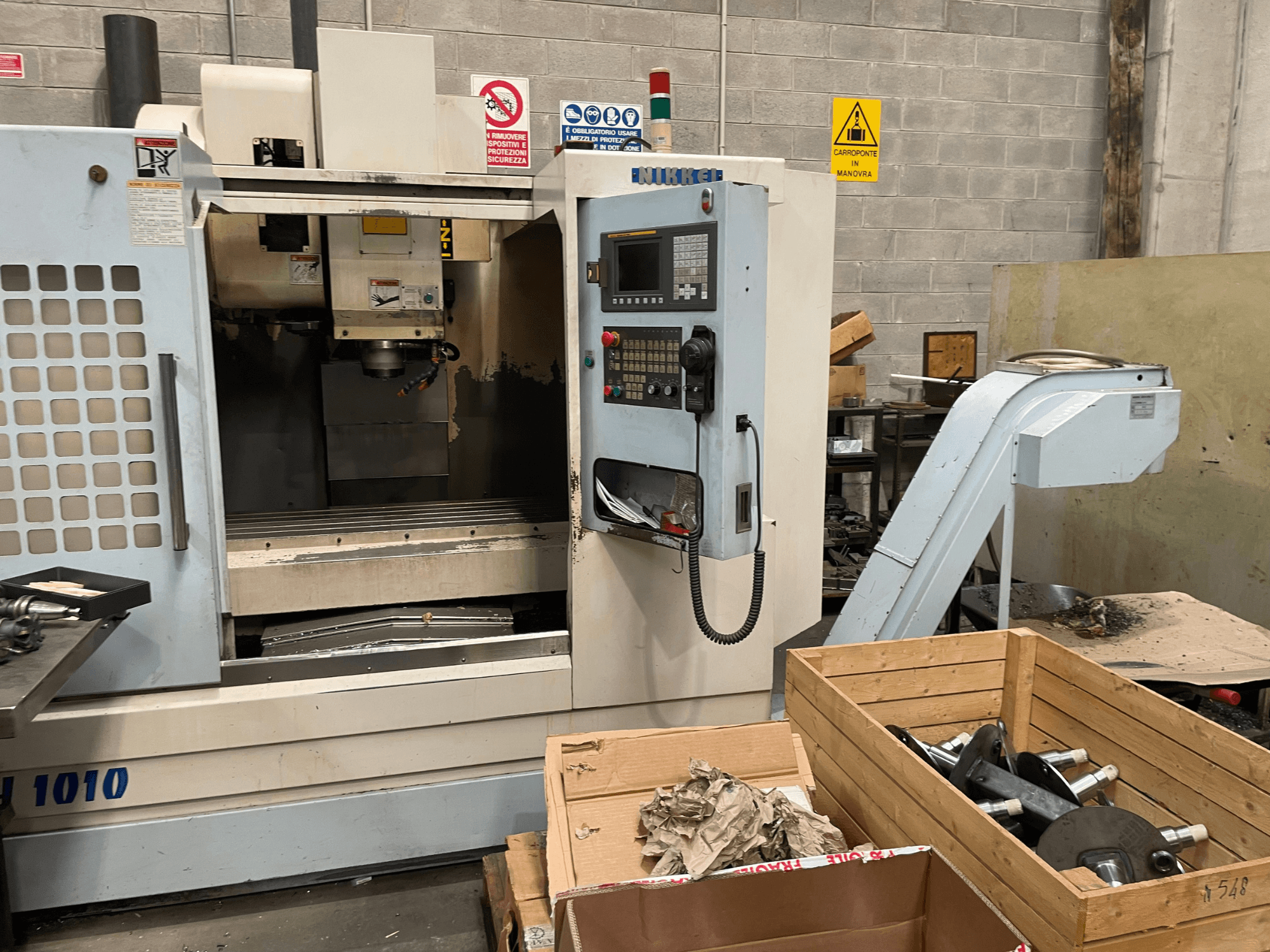 Verticaal bewerkingscentrum van Other, model VH-1010, gezien vanaf de voorkant met bedieningselementen zichtbaar en dozen in de buurt.