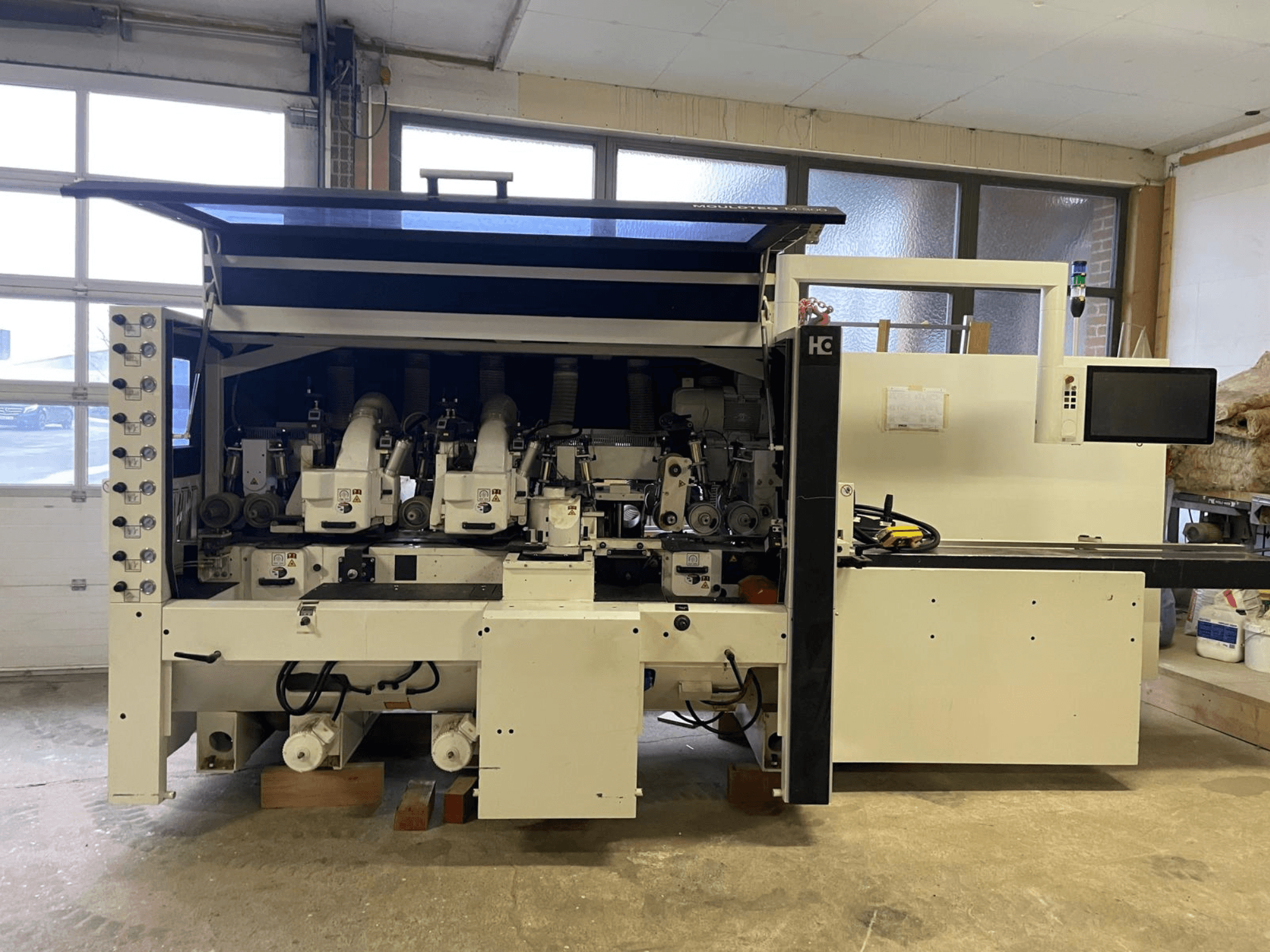 Häwa CNC machine, vooraanzicht, met meerdere spindels, bedieningspaneel en stofafzuigslangen, geschikt voor houtbewerking.