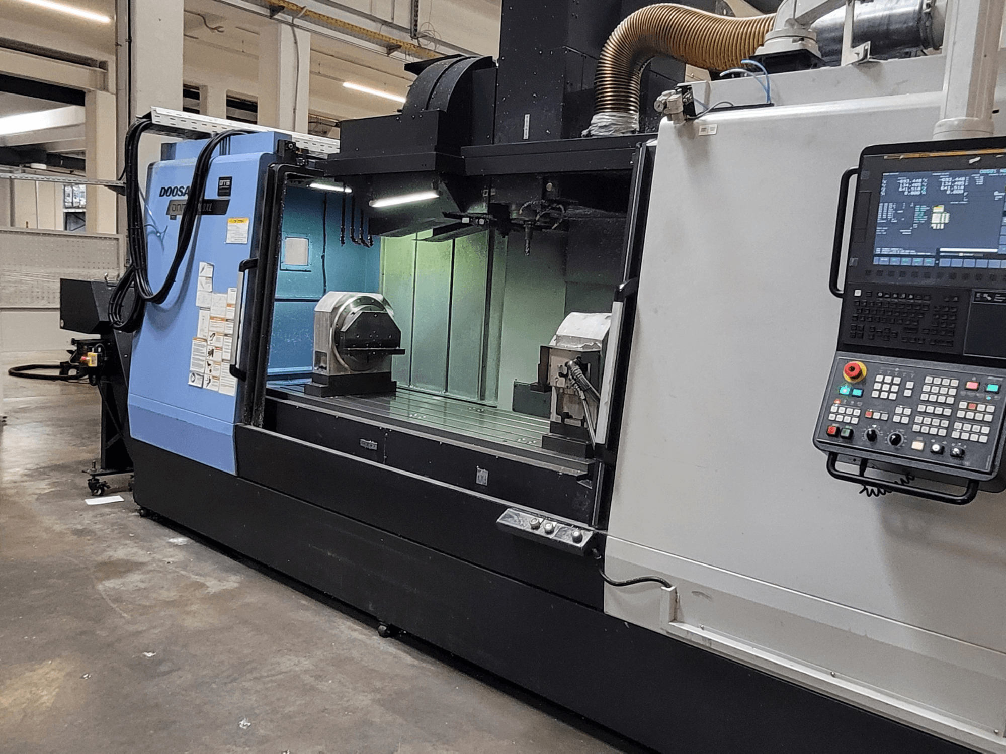 DOOSAN DNM 6700 XL verticaal bewerkingscentrum, vooraanzicht met bedieningspaneel, werktafel en bewerkingsgebied.