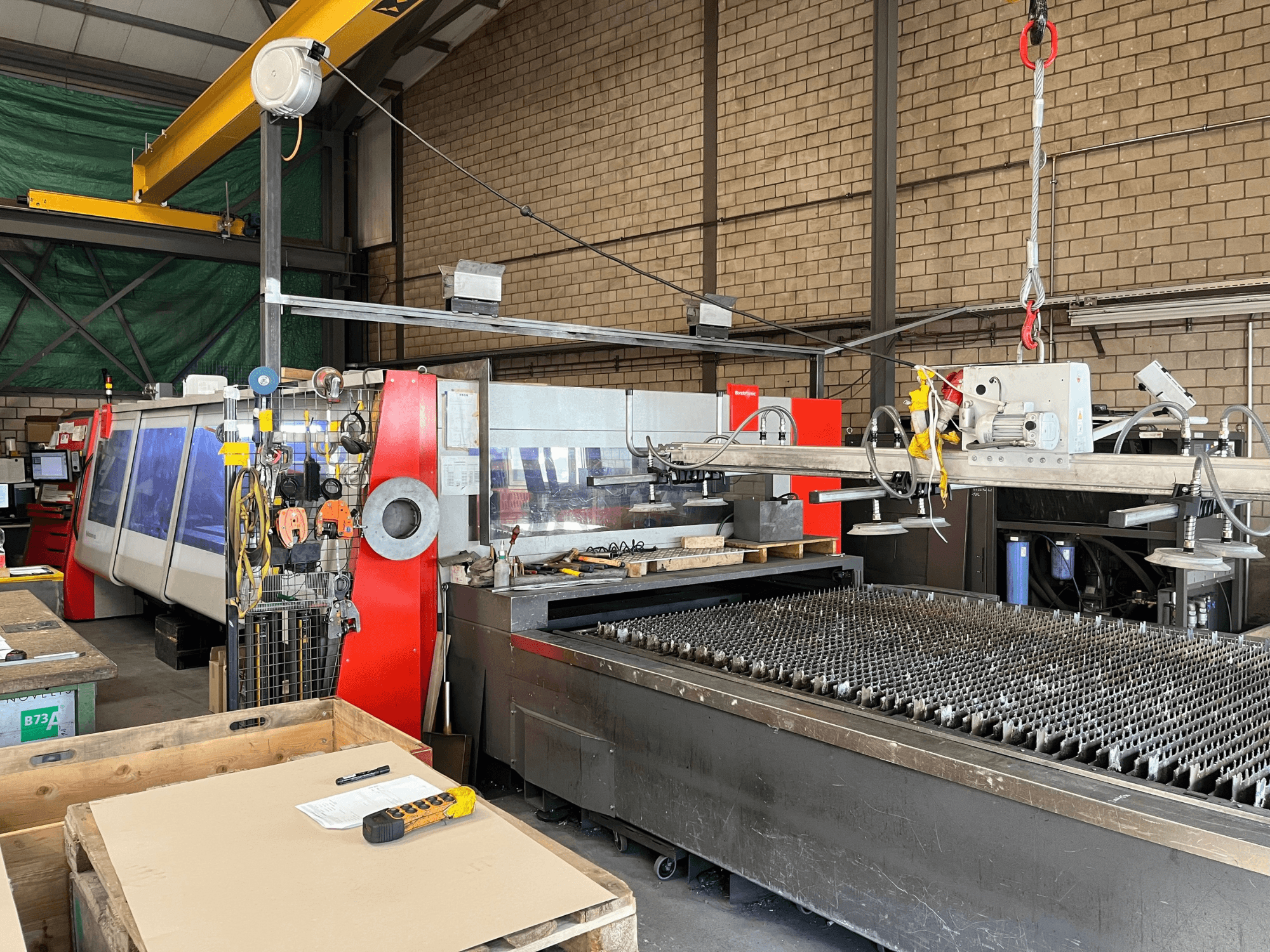 CO₂-lasersnijmachine Bystronic ByAutonom 4020, zijaanzicht met werktafel, bedieningspaneel en bovenloopkraan op de achtergrond.