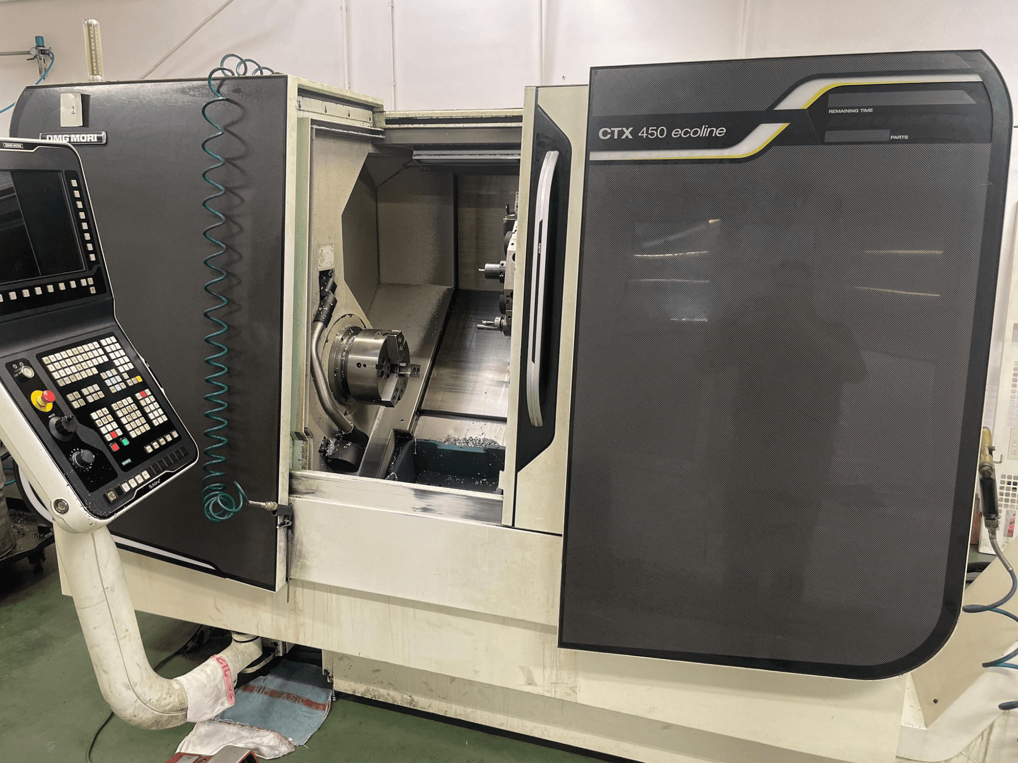 DMG MORI CTX 450 ecoline CNC machine in zijaanzicht, met bedieningspaneel, klauwplaat en bewerkingsgebied.