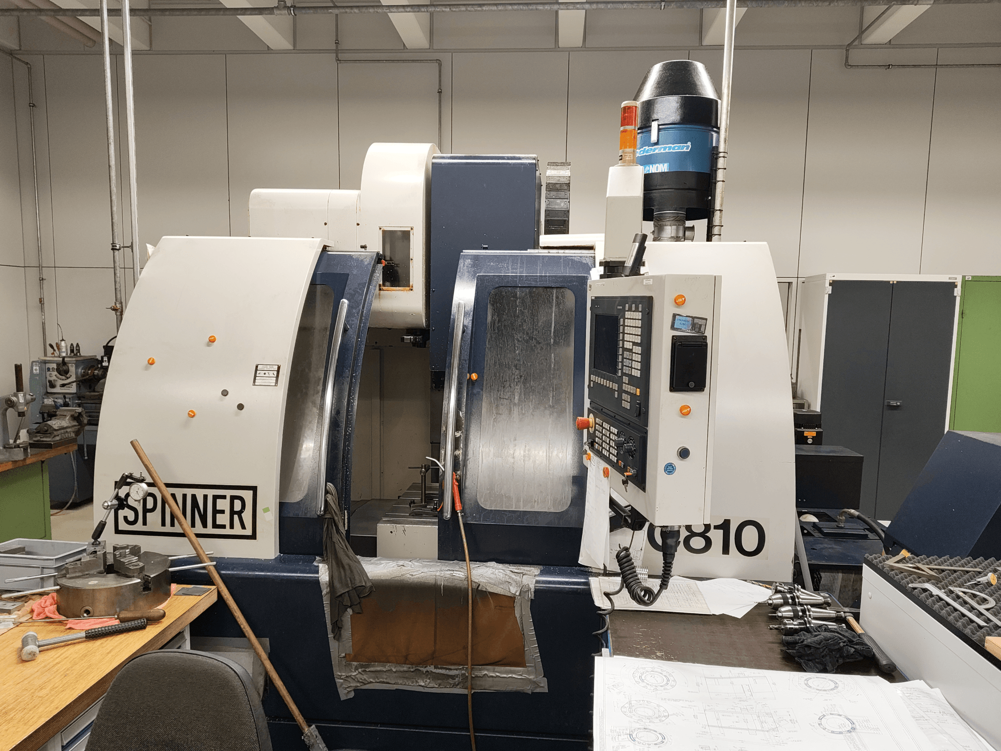 SPINNER VC810 verticaal bewerkingscentrum, vooraanzicht, met het bedieningspaneel, het werkgebied en de gemonteerde gereedschappen.