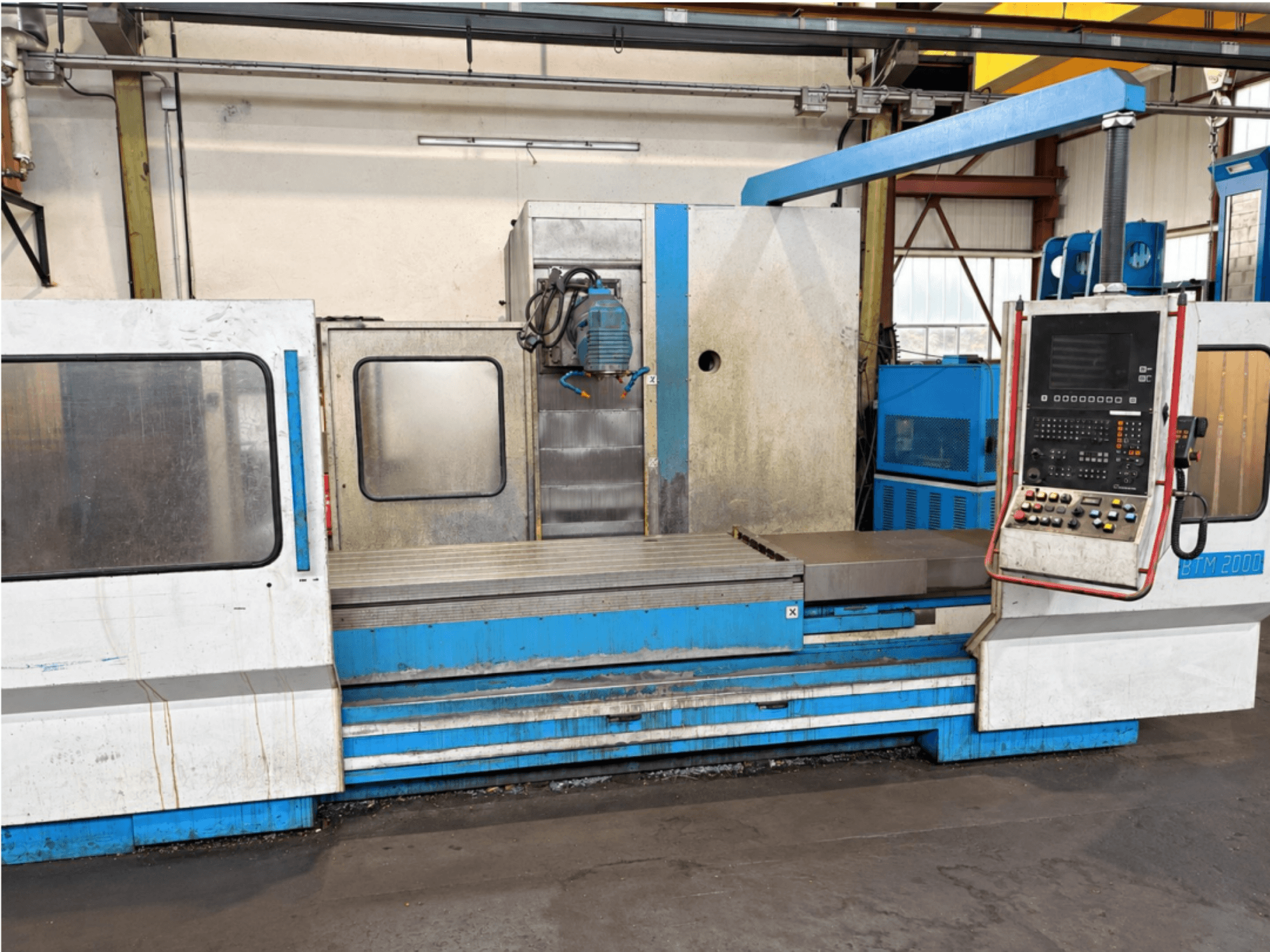 De MIKRON BTM 2000 vlakslijpmachine, gezien vanaf de voorkant, met het bedieningspaneel en de slijptafel.