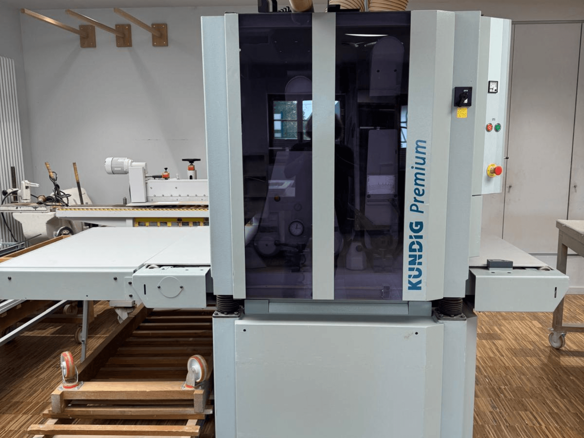 Kundig Premium 2-1100-RP bandschuurmachine in vooraanzicht met bedieningspaneel en grote glazen behuizing voor zichtbaarheid.