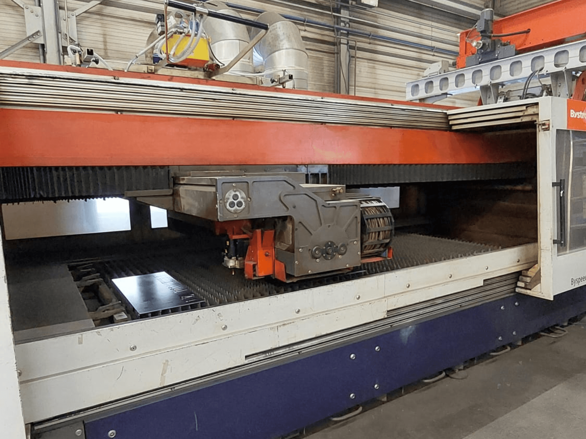 Bystronic BySpeed 3015 CO₂-lasersnijmachine, vooraanzicht met de snijkop en de metalen plaat op het snijbed.