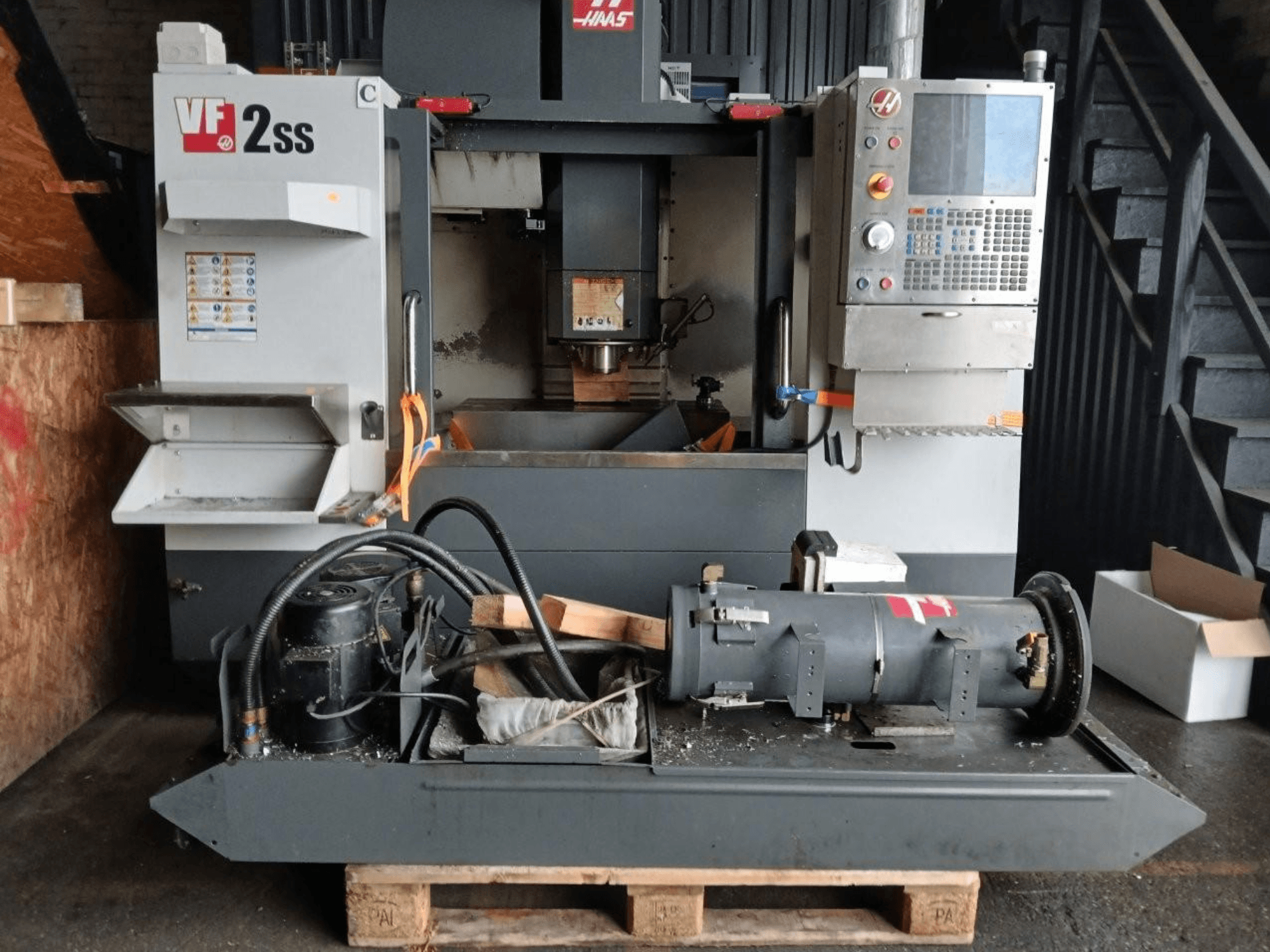 Verticaal bewerkingscentrum HAAS VF-2SS in vooraanzicht, met het bedieningspaneel, het spindelgedeelte en de aangesloten motoronderdelen.