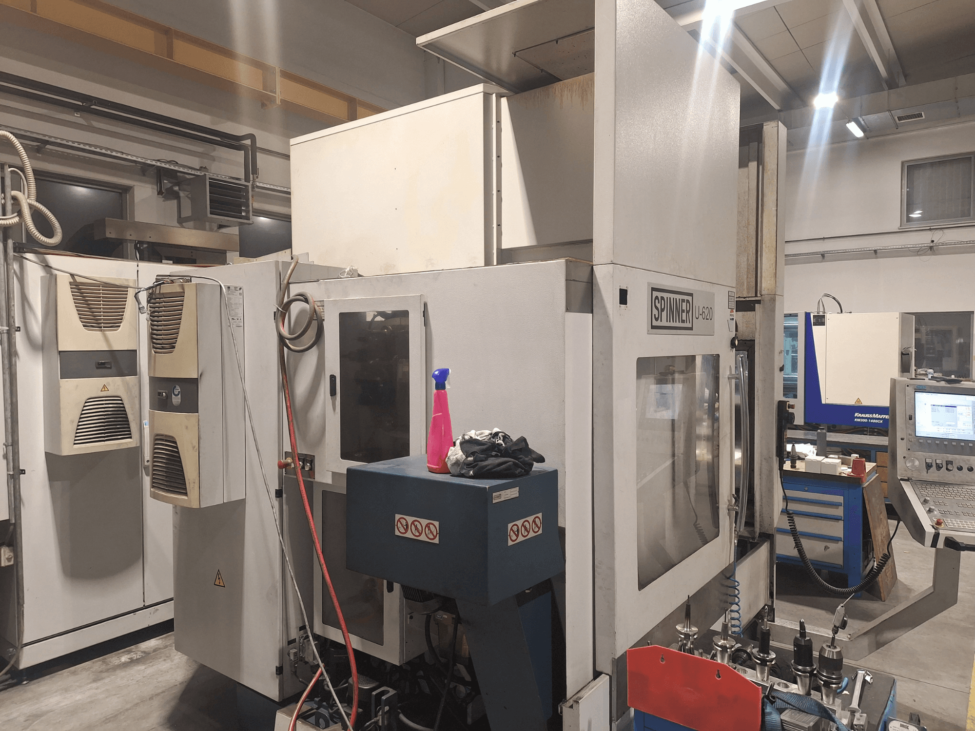Spinner U-620 CNC machine in vooraanzicht in een werkplaats, met bedieningspaneel en diverse gereedschappen op een werkbank vlakbij.