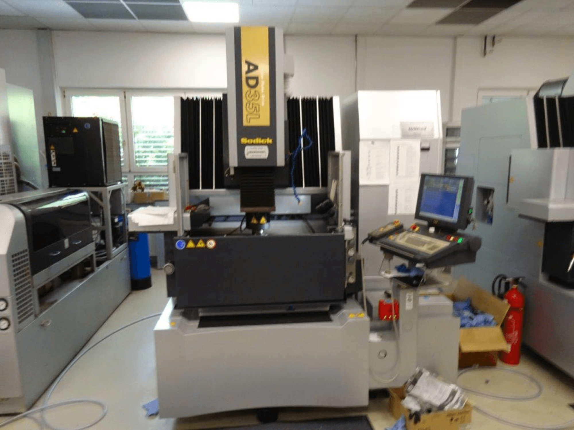 Sodick AD35L CNC machine vanuit vooraanzicht, met bedieningspaneel, koeleenheid en veiligheidsindicatoren.