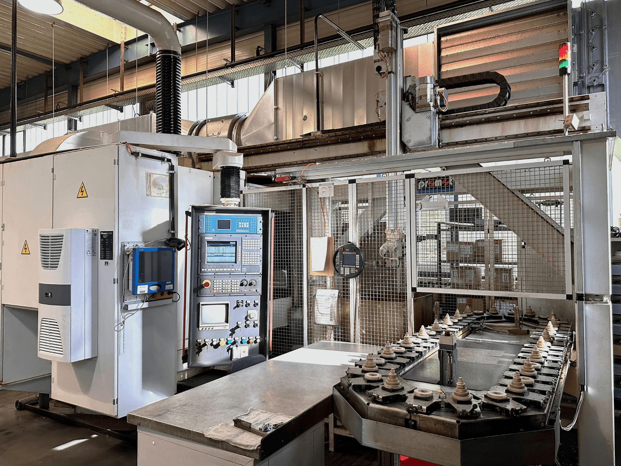 Industriële machines met bedieningspaneel, koeleenheid en transportband. Vooraanzicht, met felle lampen en veiligheidsborden.